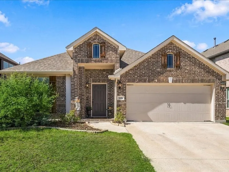 Brick exterior with architectural gables, attached two-car garage, and a covered entry