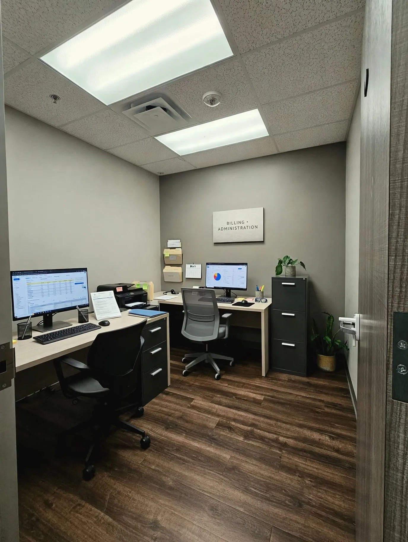 Recessed fluorescent lighting, wood-finish flooring, and light gray wall paint
