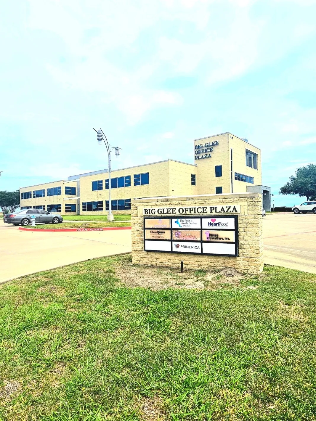 Brick facade office building featuring multiple windows and a prominent exterior sign