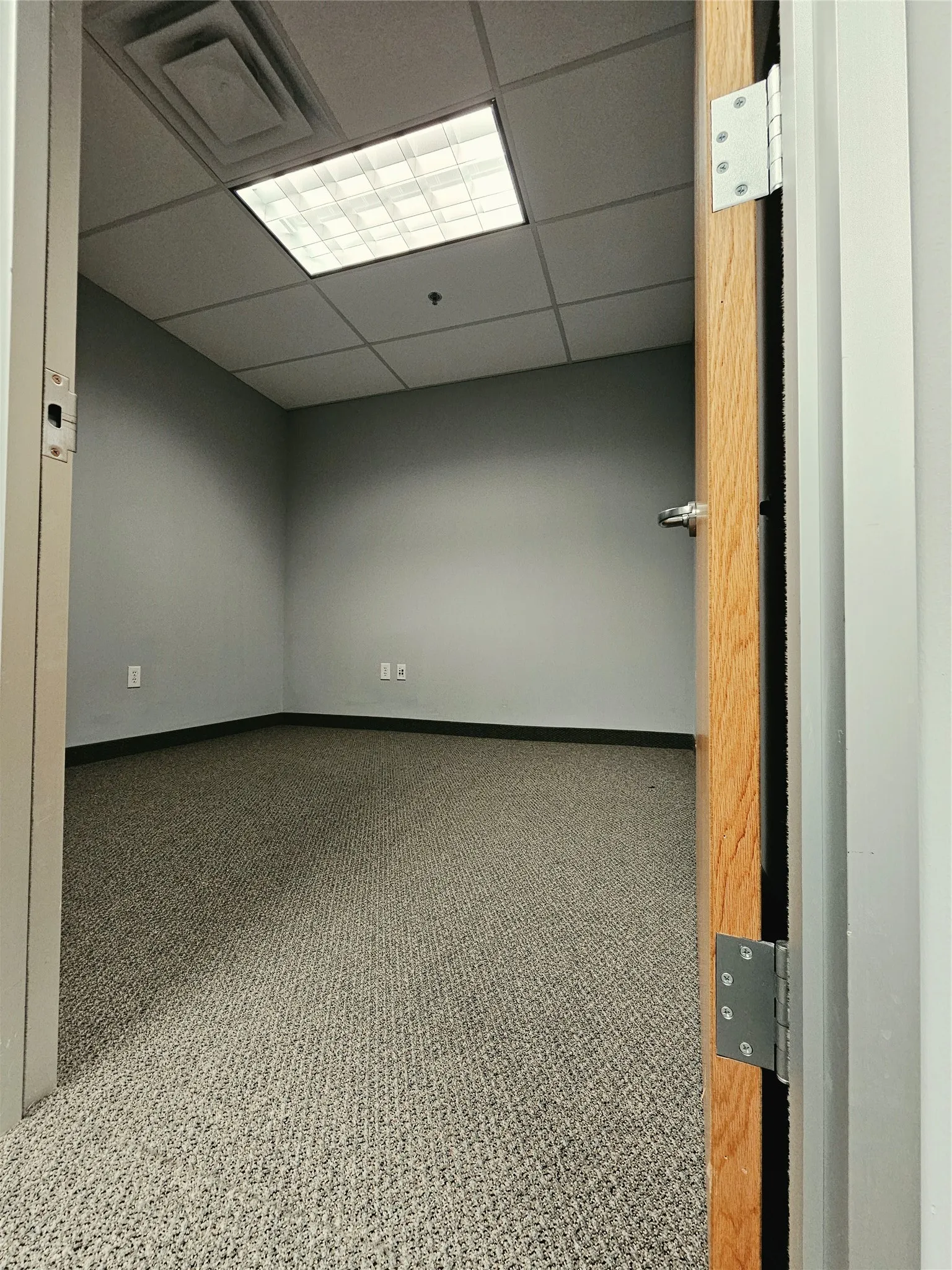 Commercial carpet flooring with a drop ceiling featuring recessed lighting