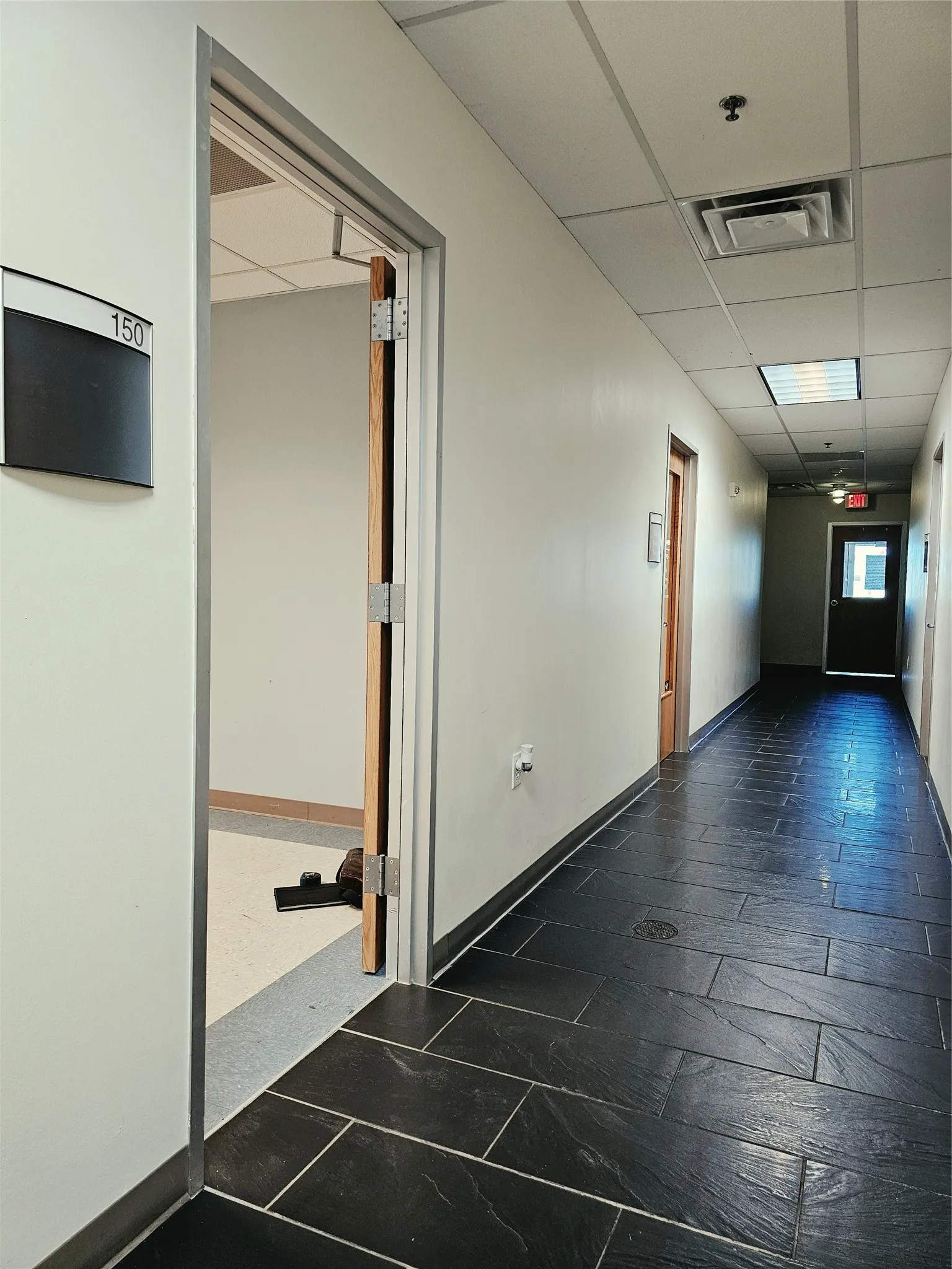 Black rectangular tile flooring throughout the hallway