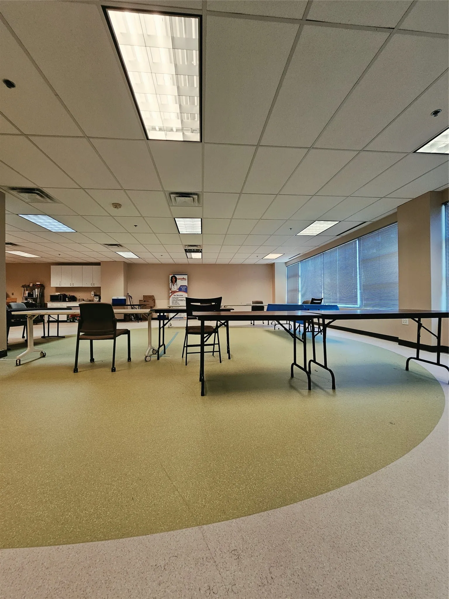Spacious room with dropped ceiling, recessed lighting, and expansive windows