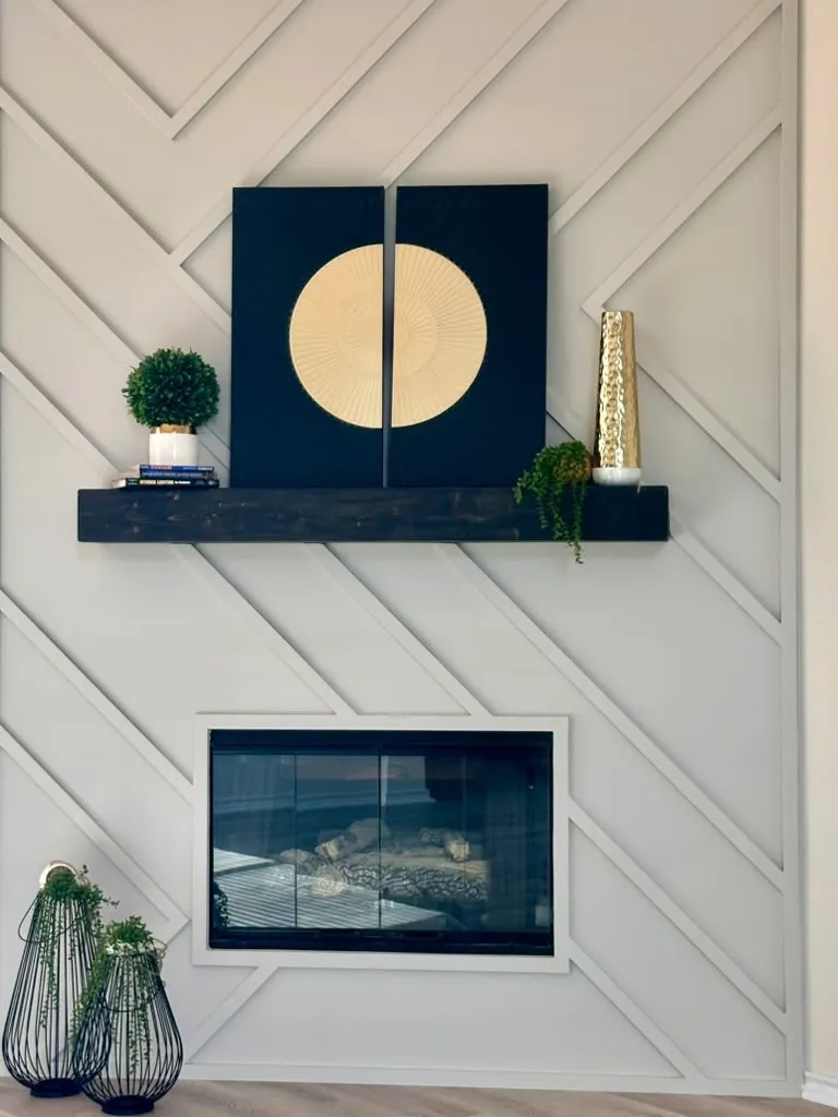 Fireplace accent wall featuring a geometric lattice molding design, dark-stained timber mantel, and glass-front fireplace insert
