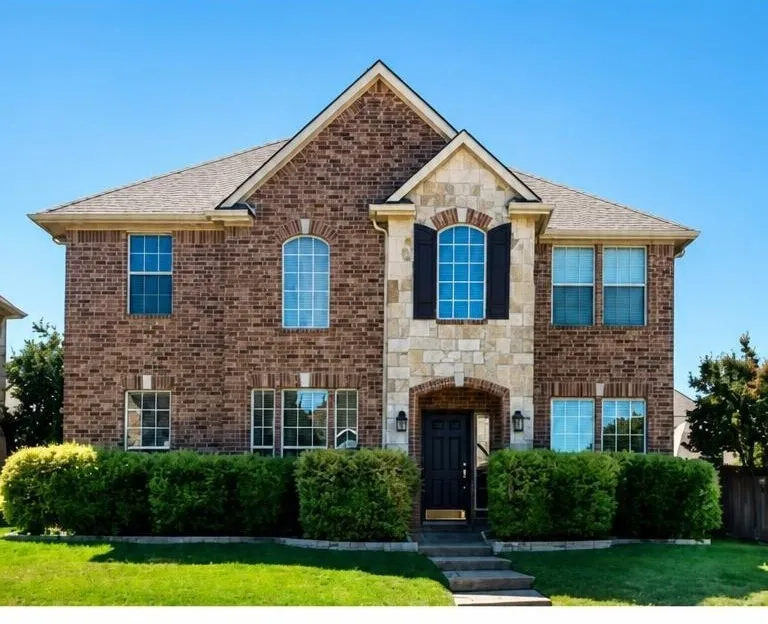 Two-story brick exterior with stone accents, arched entryway, and dark-paneled door