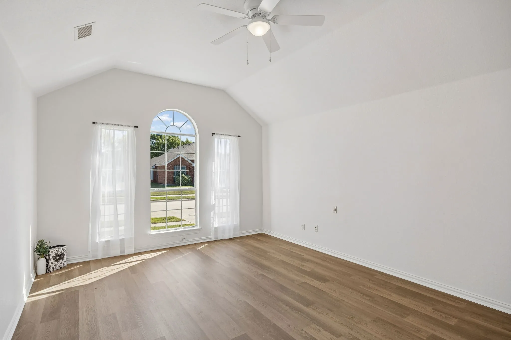 And Now... welcome to the Primary Bedroom retreat! Vaulted ceiling, arched windows and beautiful wood look flooring make this room special!