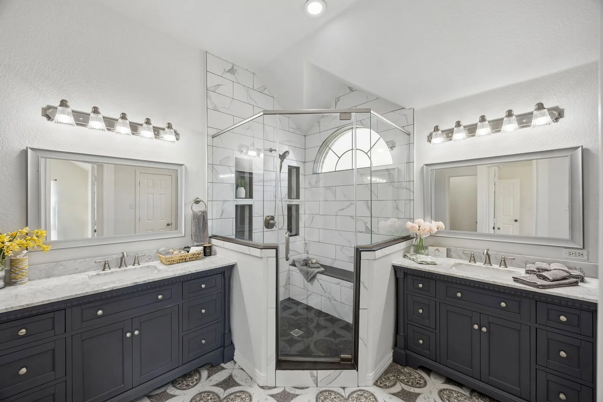 This beautifully designed bathroom features two spacious vanities, stylish finishes and an impressive glass-enclosed walk-in shower with seating!