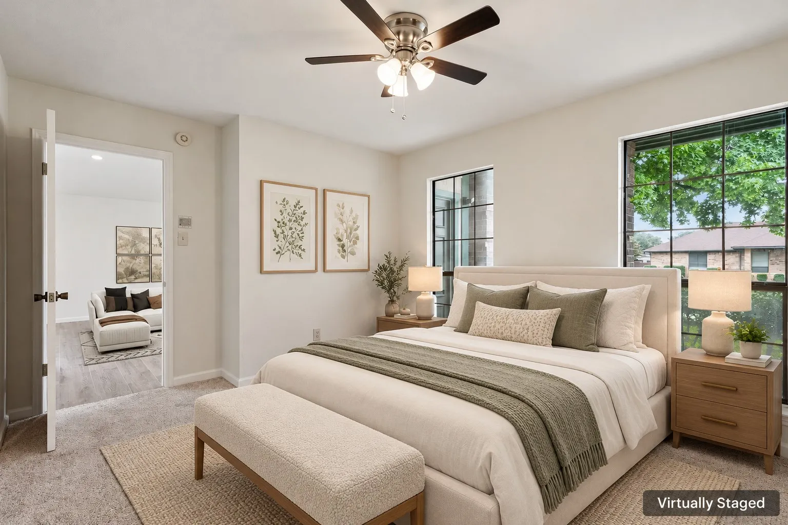 Carpeted bedroom with a ceiling fan, two windows featuring grid patterns, and a doorway opening to an adjacent room with wood-finish flooring