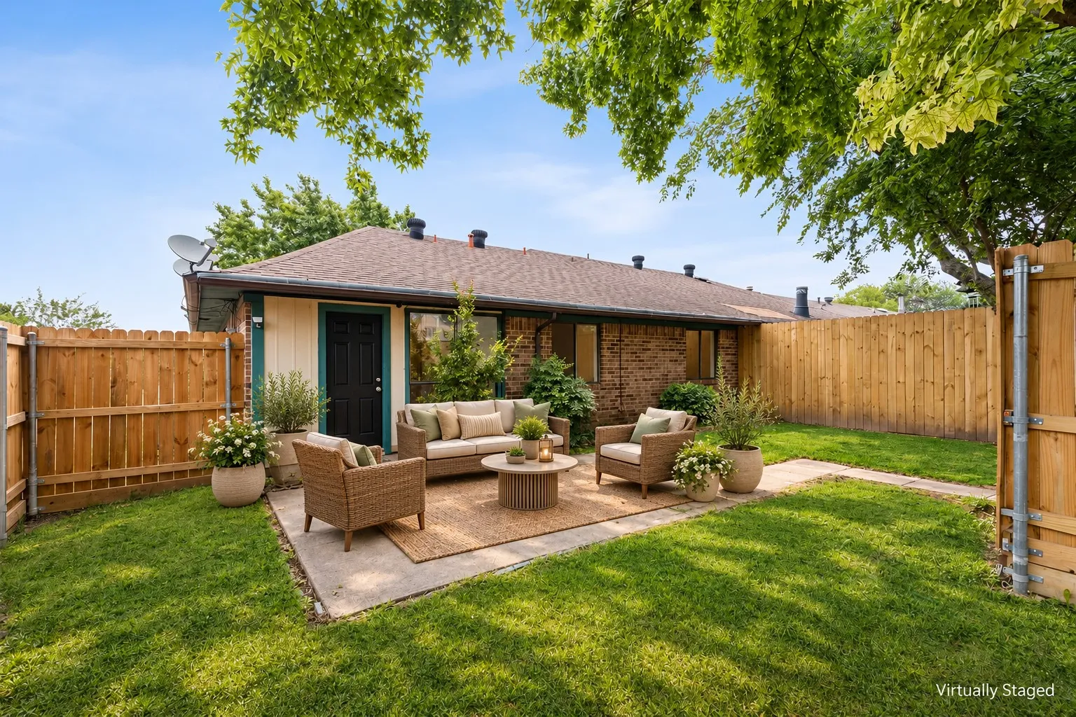 Private backyard featuring a concrete patio, wood fencing, and a manicured lawn