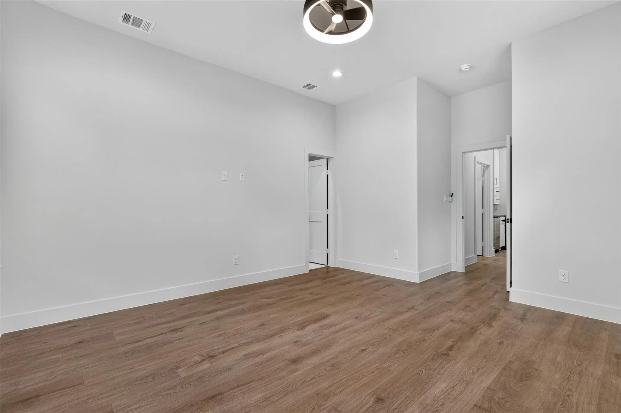 Wood-finish flooring, recessed lighting, and a modern ceiling fixture