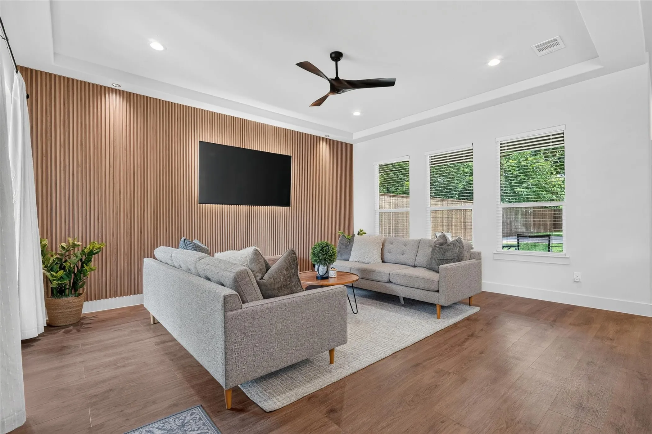 Wood-finish flooring throughout, recessed lighting, and a modern ceiling fan