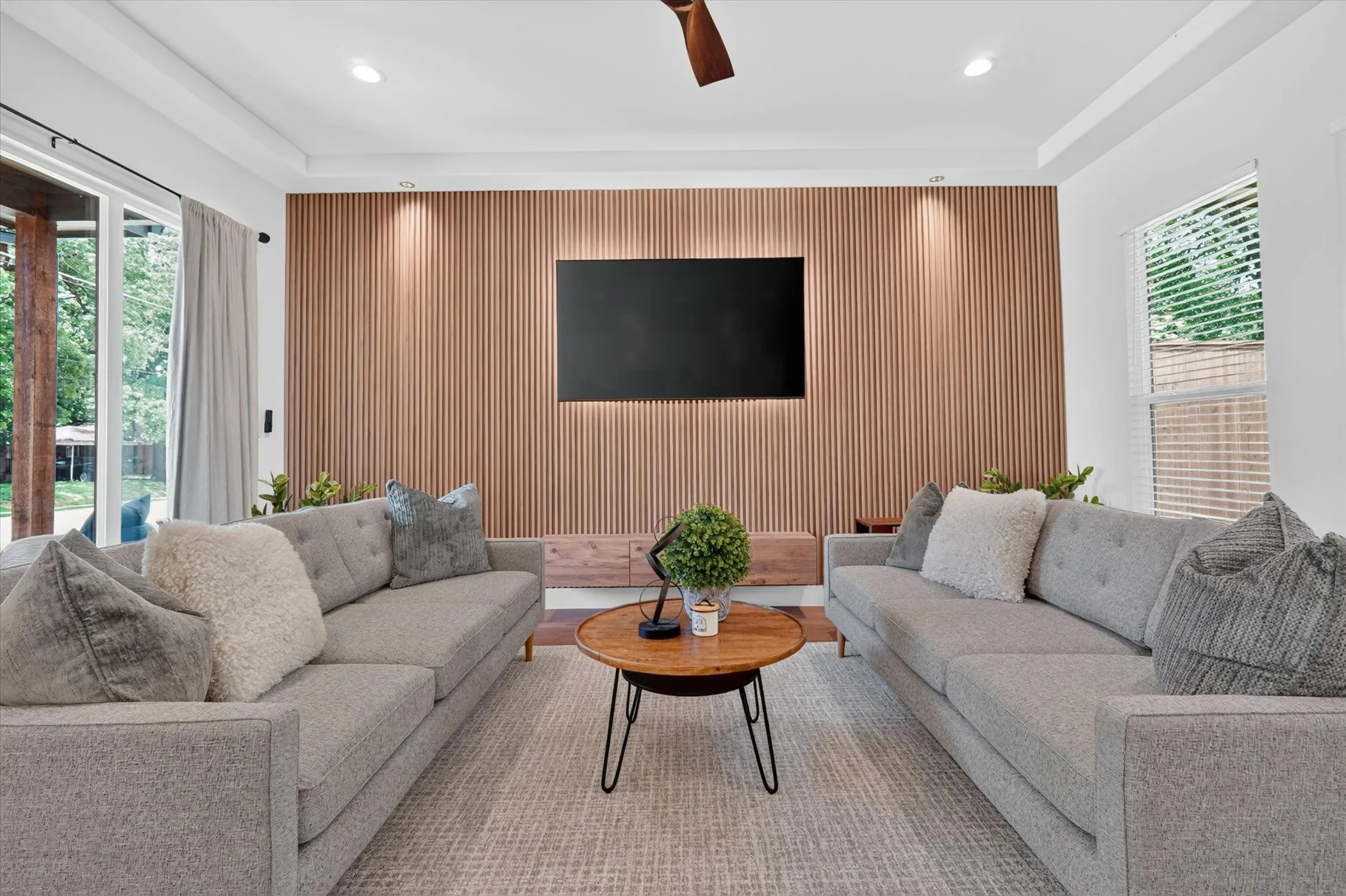 Feature wall with vertical wood paneling, recessed lighting, and a ceiling fan