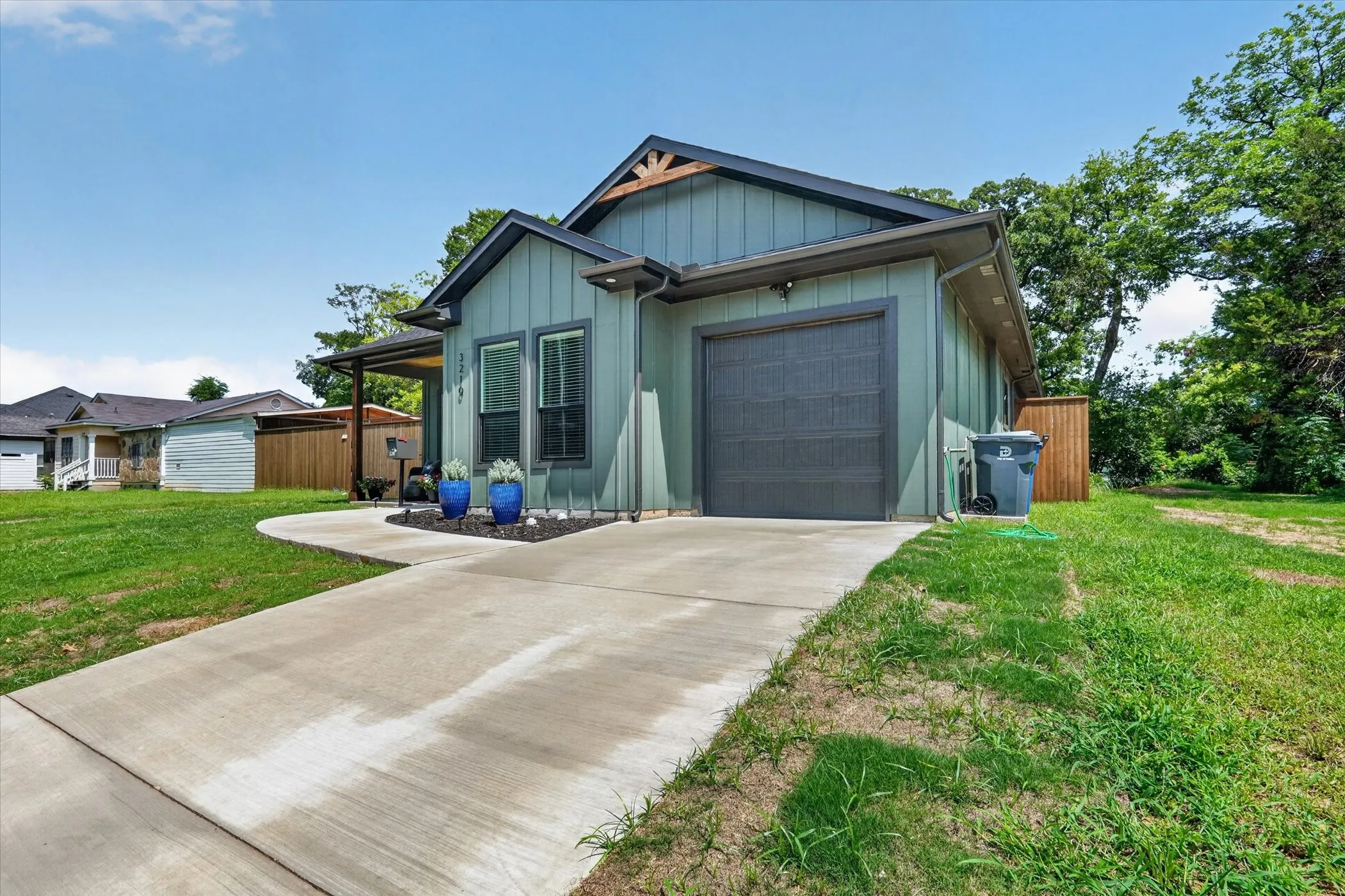 Contemporary exterior with board and batten siding, attached garage, covered entryway, and a concrete driveway