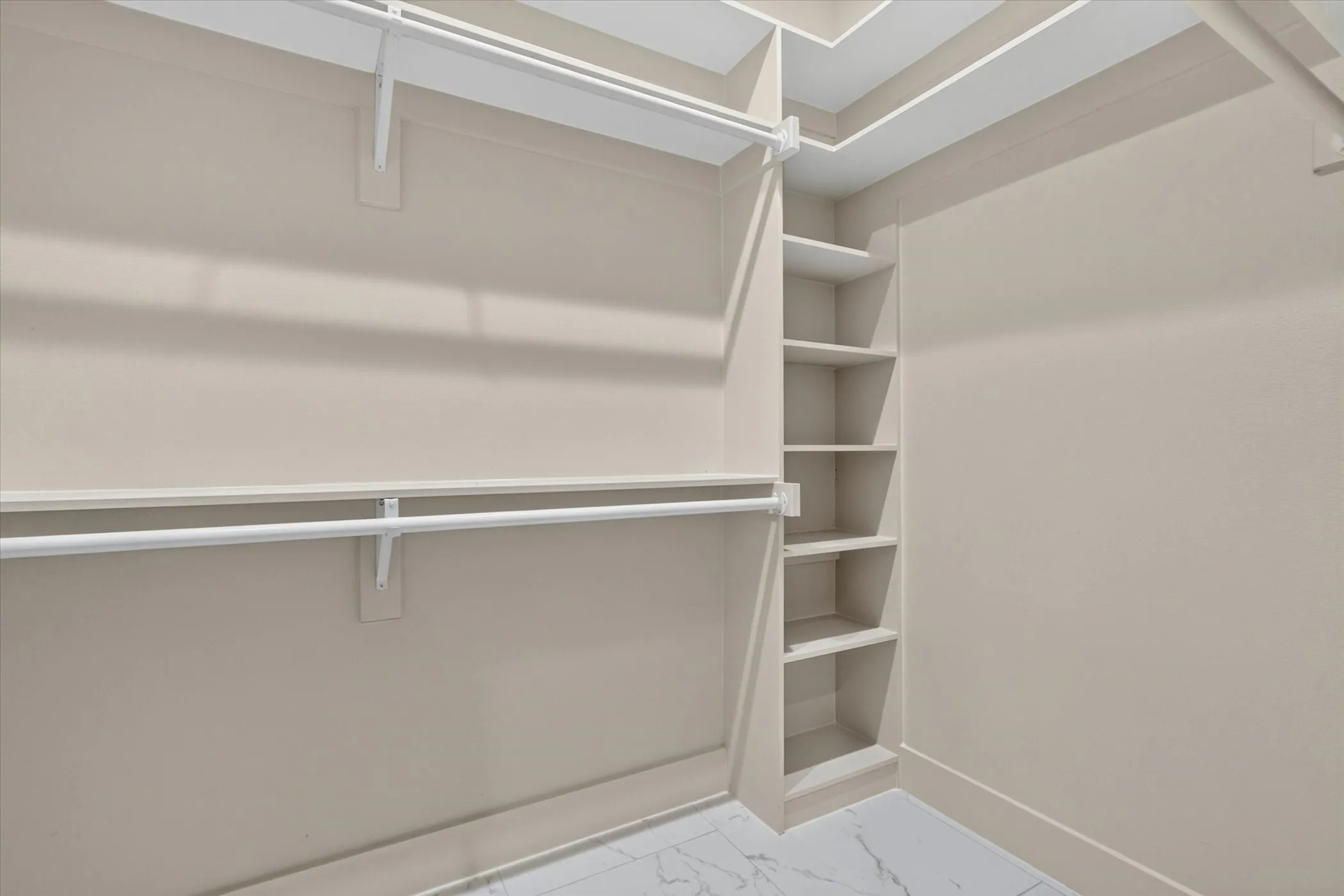 Built-in shelving, two levels of hanging rods, and light-toned walls