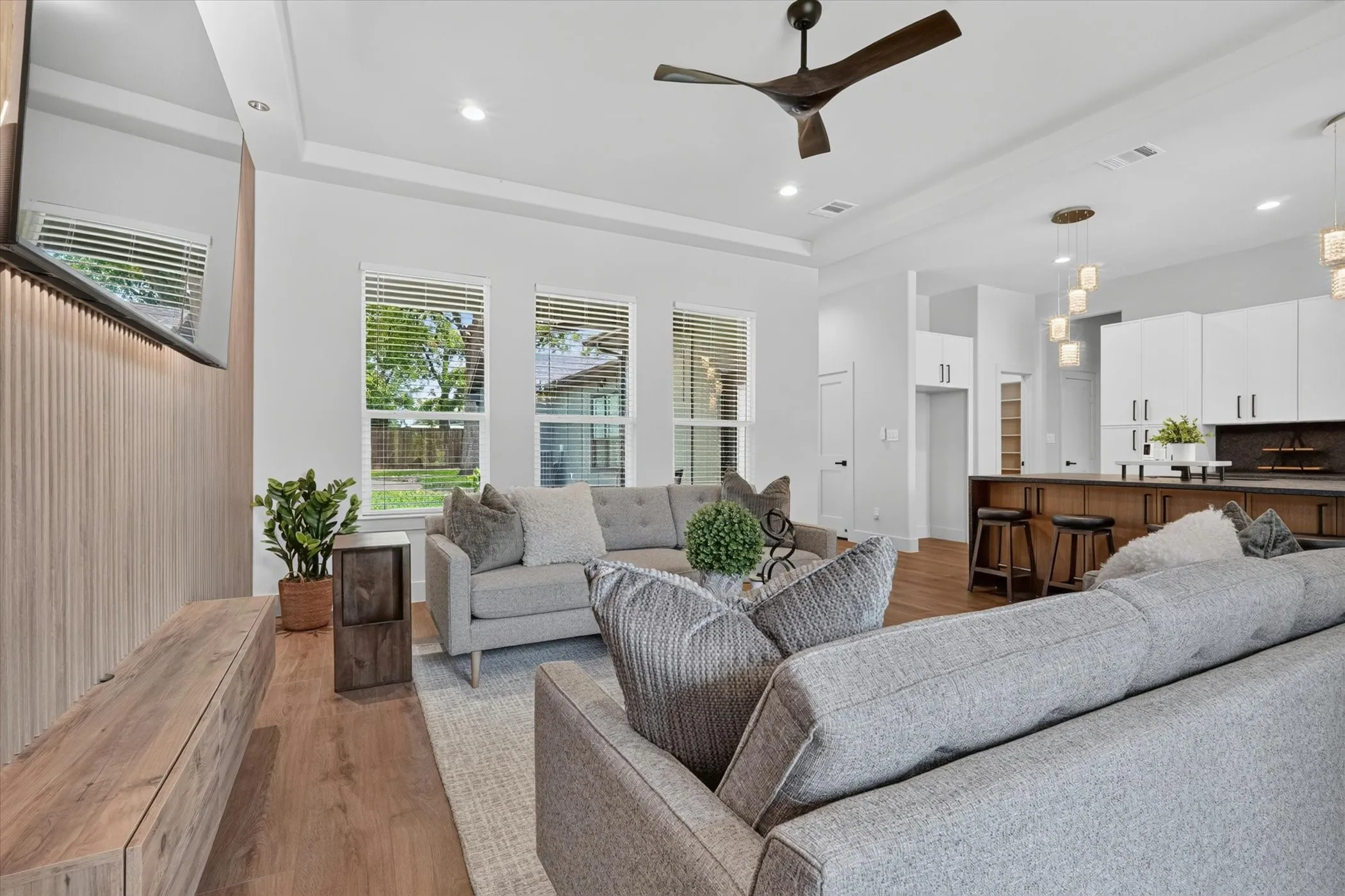 Hardwood-style flooring throughout, recessed lighting, and a modern ceiling fan
