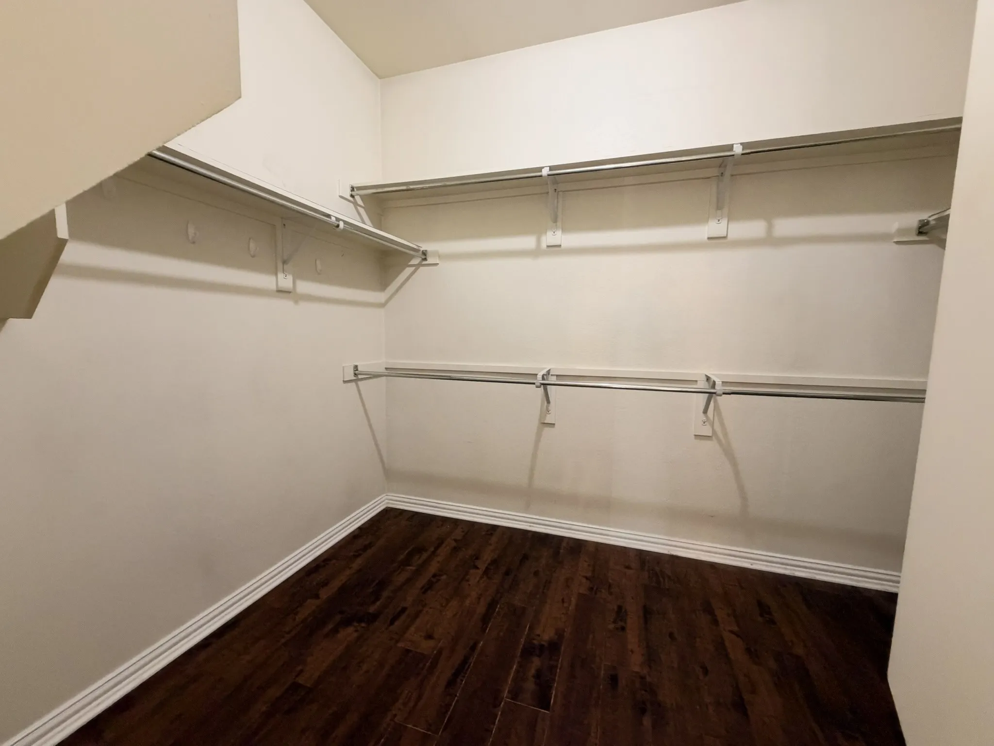 Integrated shelving, multiple hanging rods, and wood-finish flooring