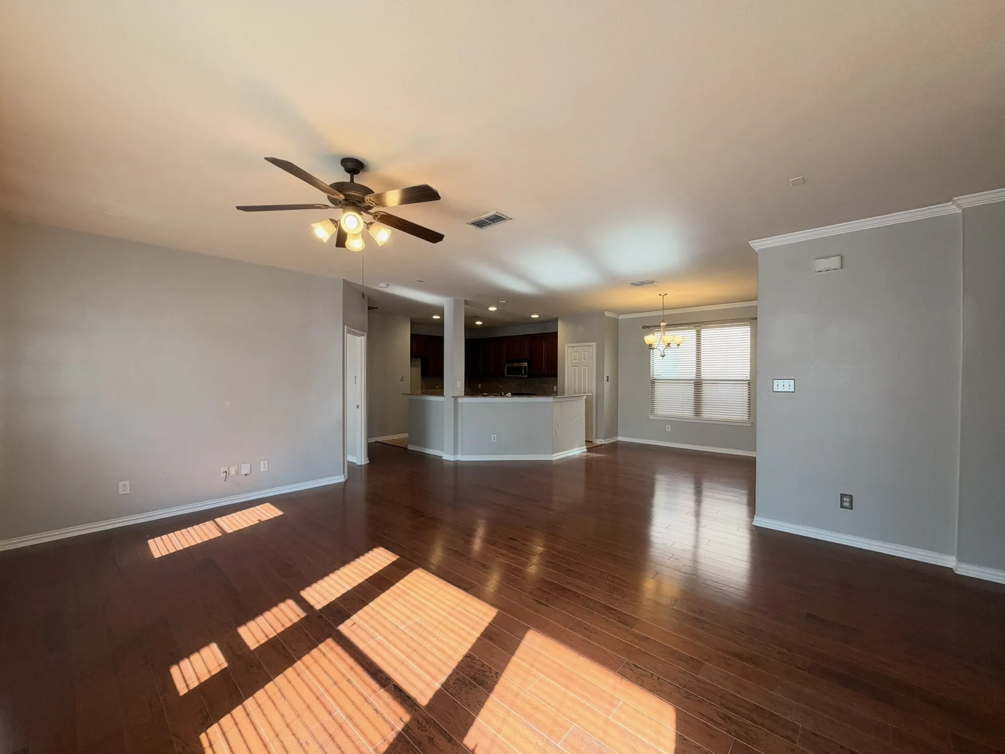 Wood-finish flooring throughout, ceiling fan with integrated lighting, recessed lighting, and crown molding