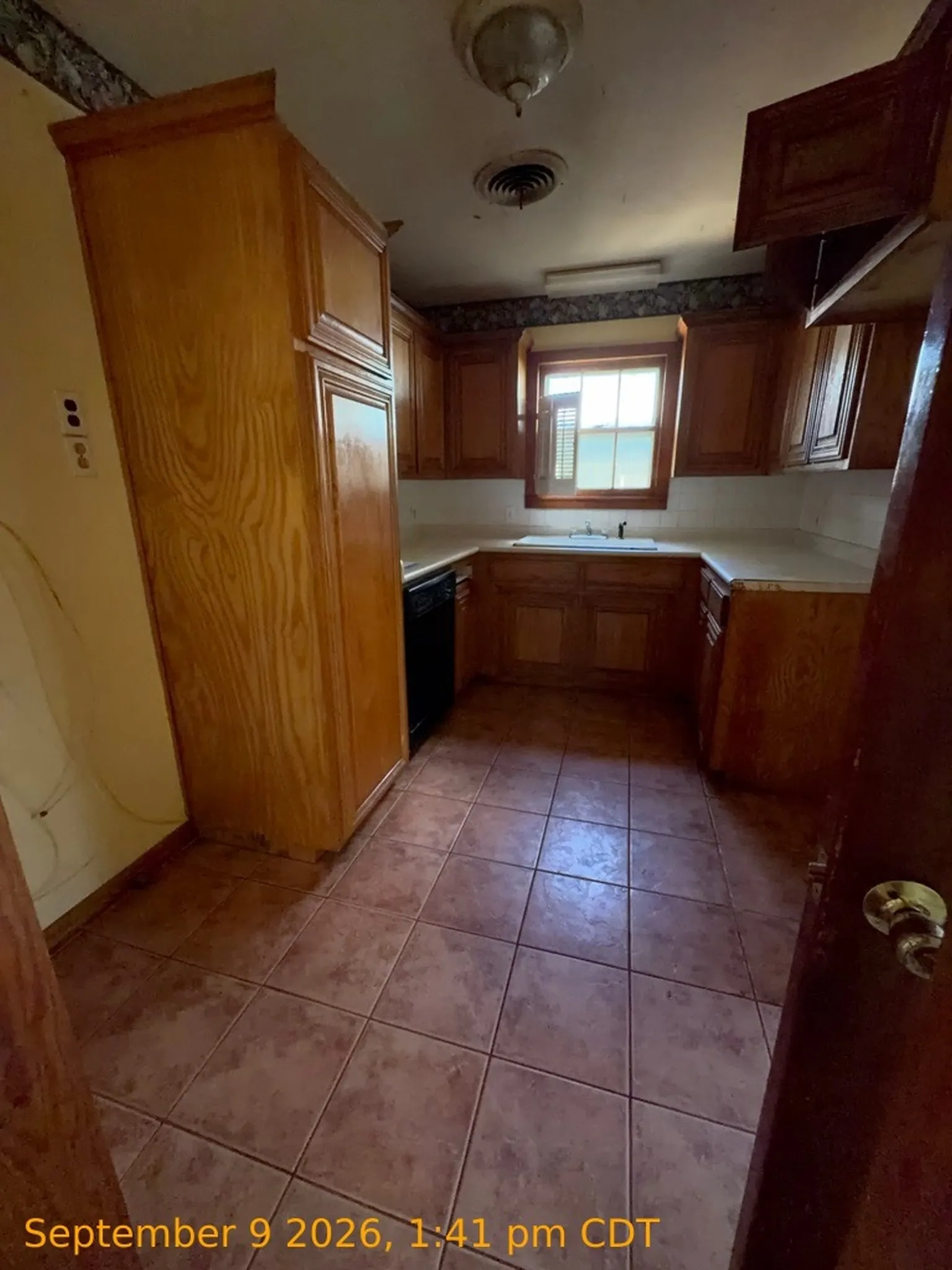 Extensive wood cabinetry, tiled flooring, built-in sink, and a built-in dishwasher