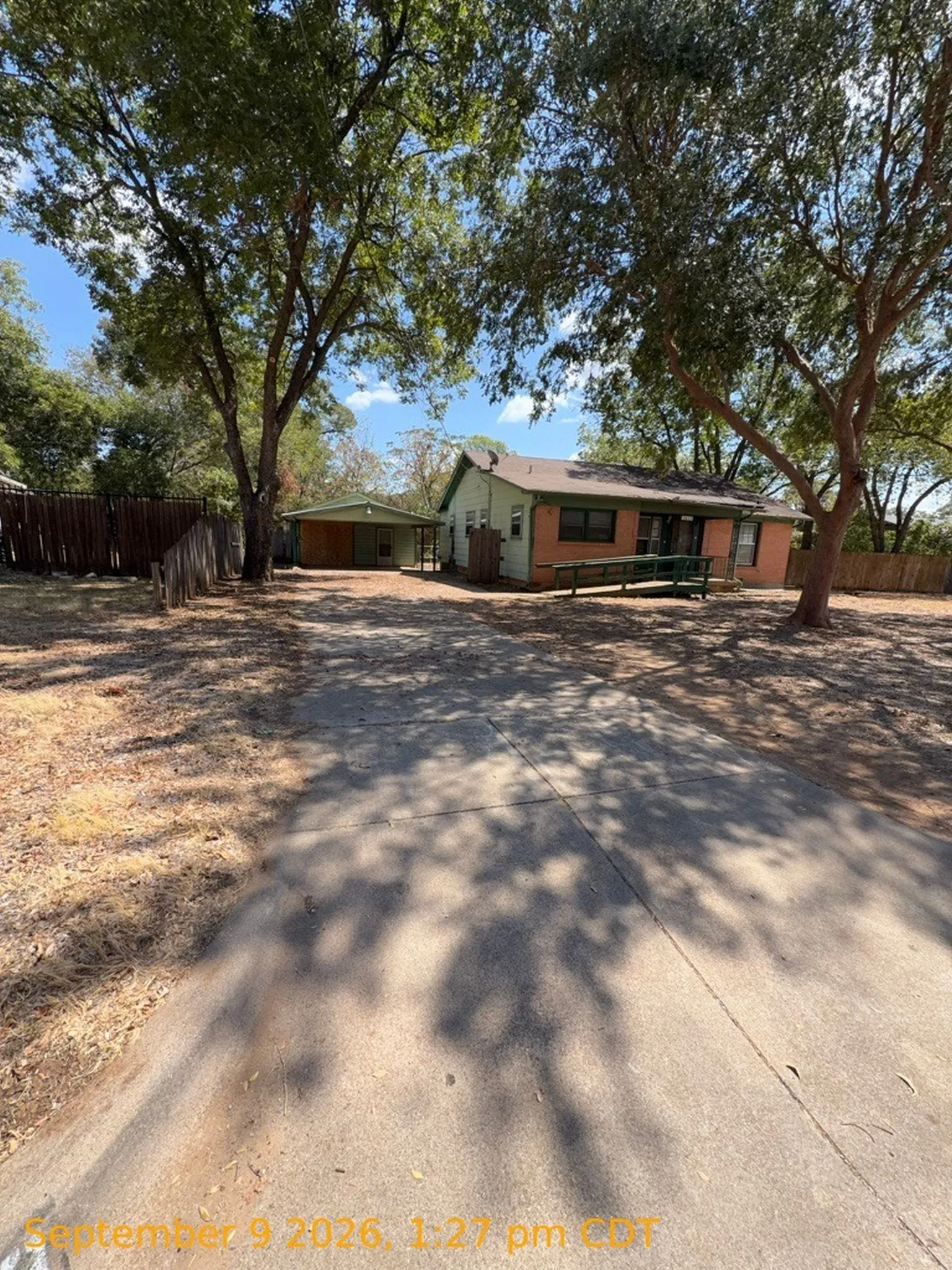 Mature trees providing natural shade, a detached garage, and a fenced perimeter