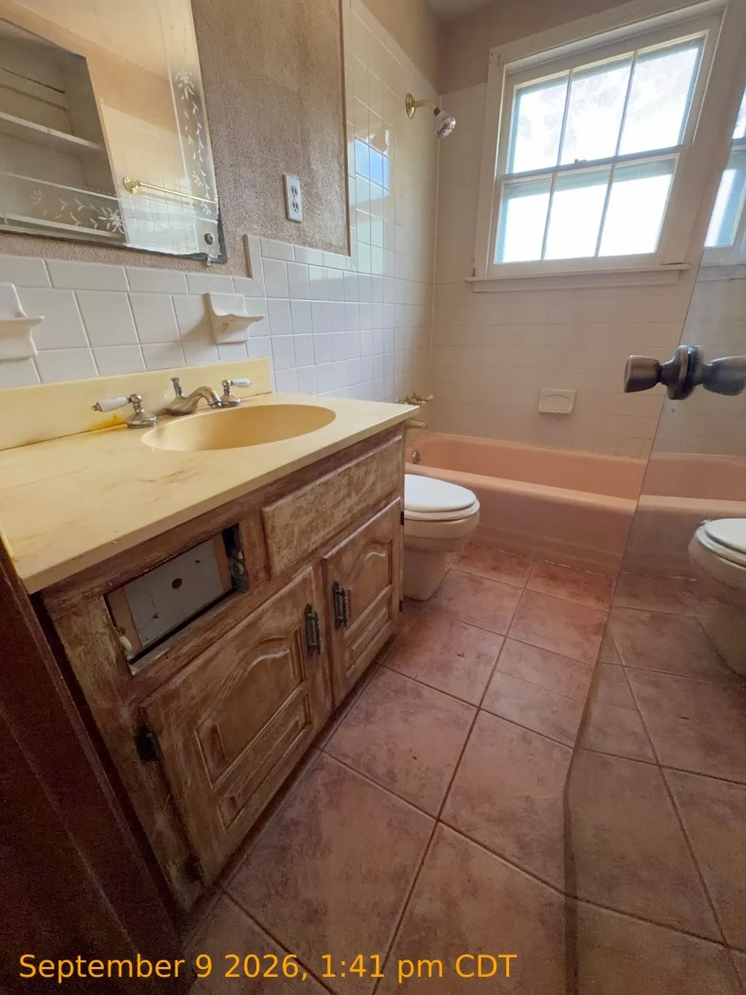 Built-in vanity with integrated sink, tile flooring, window with natural light, and a built-in bathtub