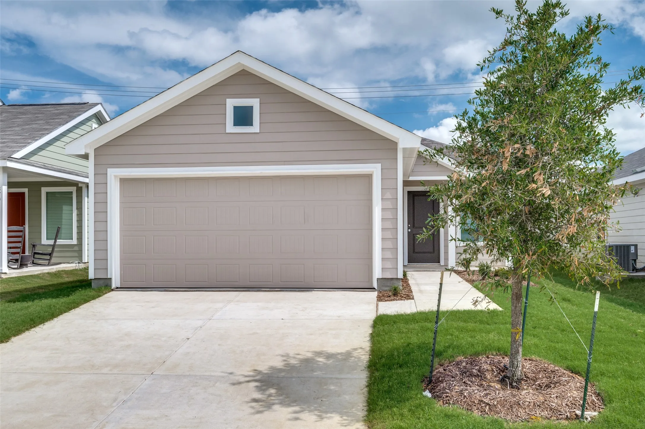 View of front of property featuring a garage, central AC, and a front lawn