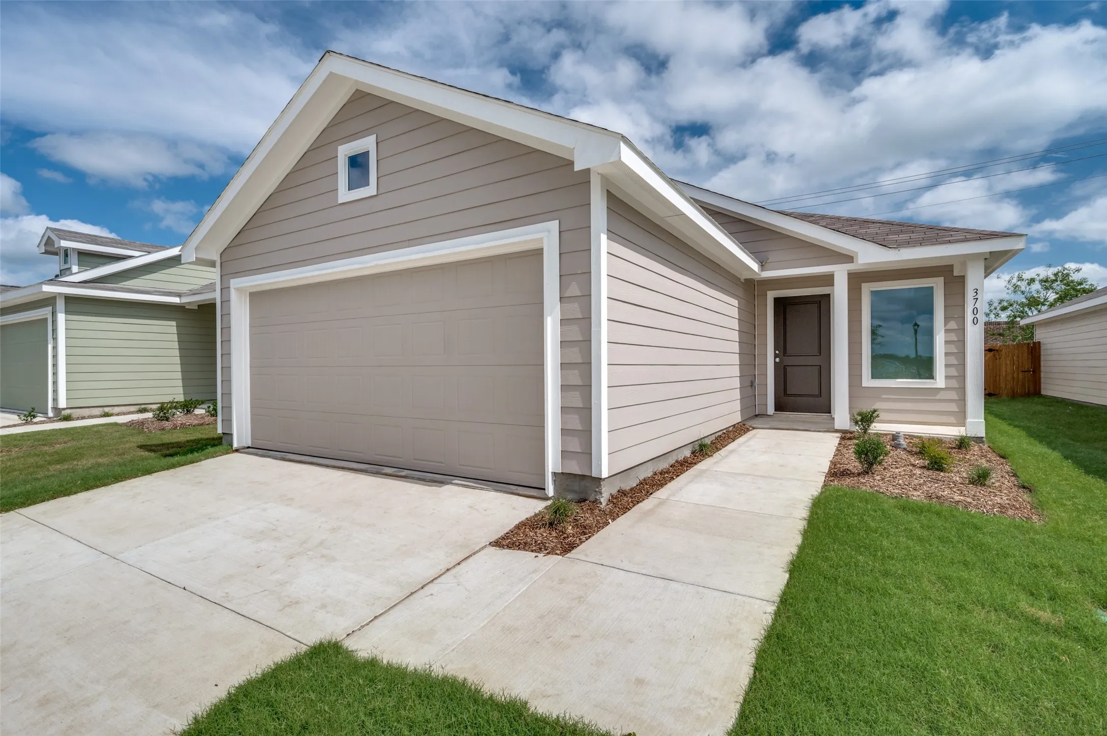 Ranch-style house featuring a front yard and a garage