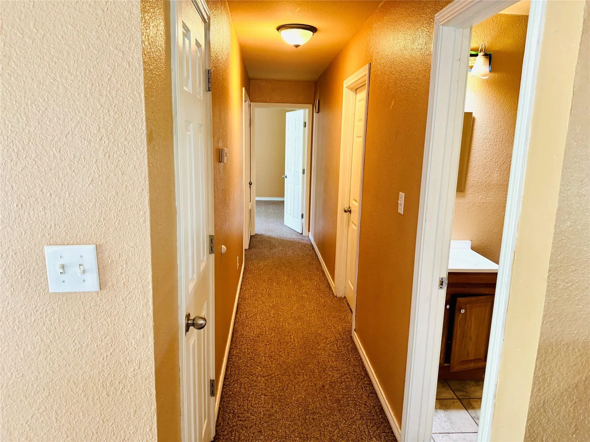 Hallway with textured walls and carpet flooring