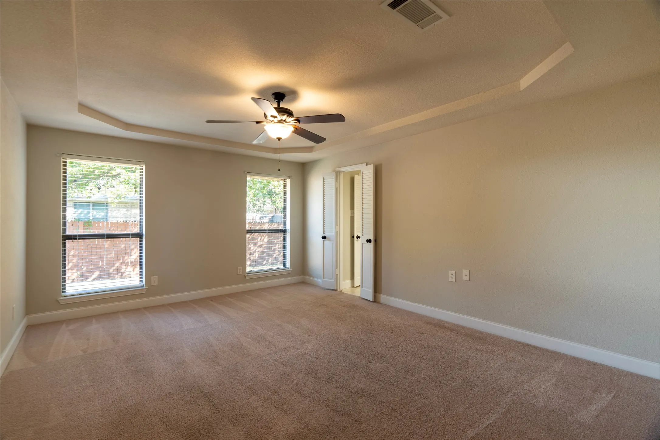 Primary bedroom with nice windows and shows entrance to bathroom