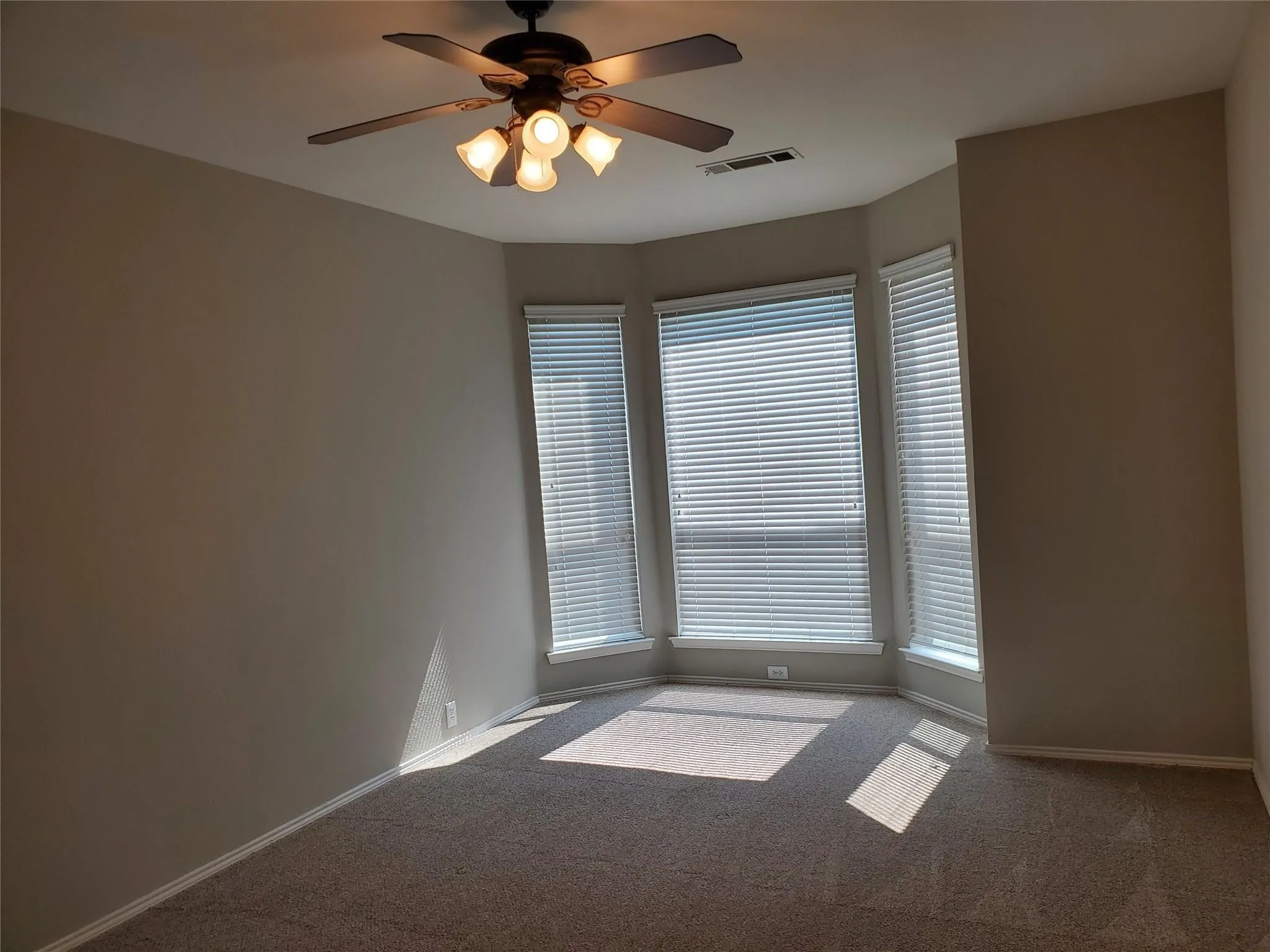 Unfurnished room featuring ceiling fan and carpet floors
