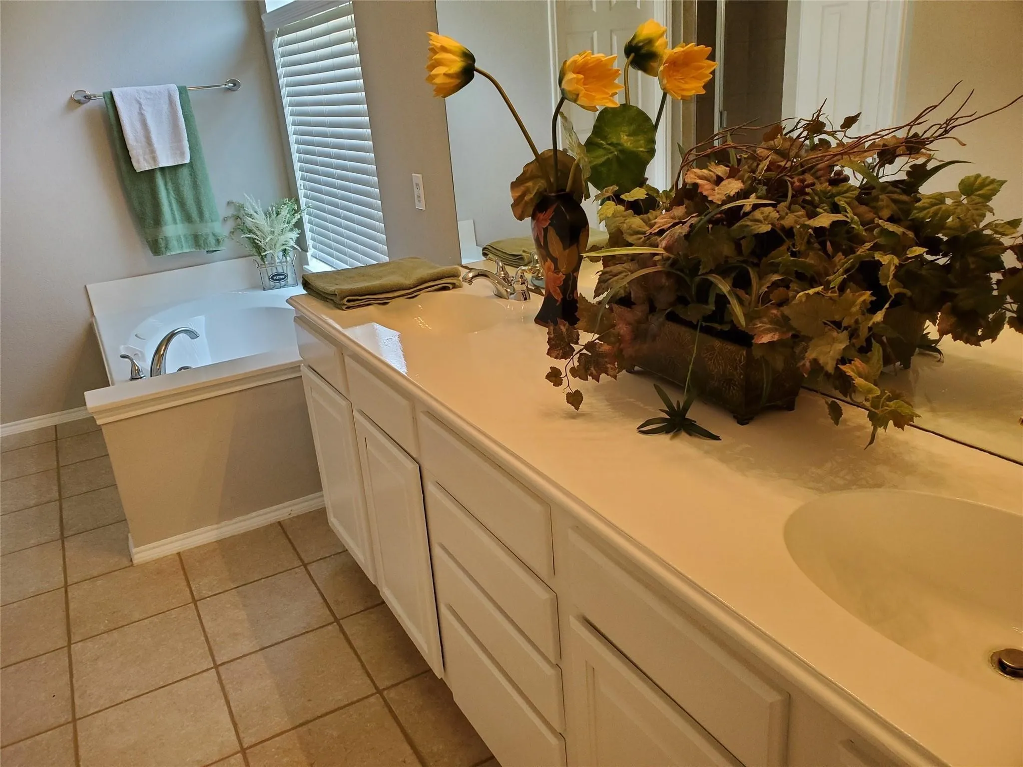 Bathroom with tile patterned floors, double sink vanity, and a bathtub