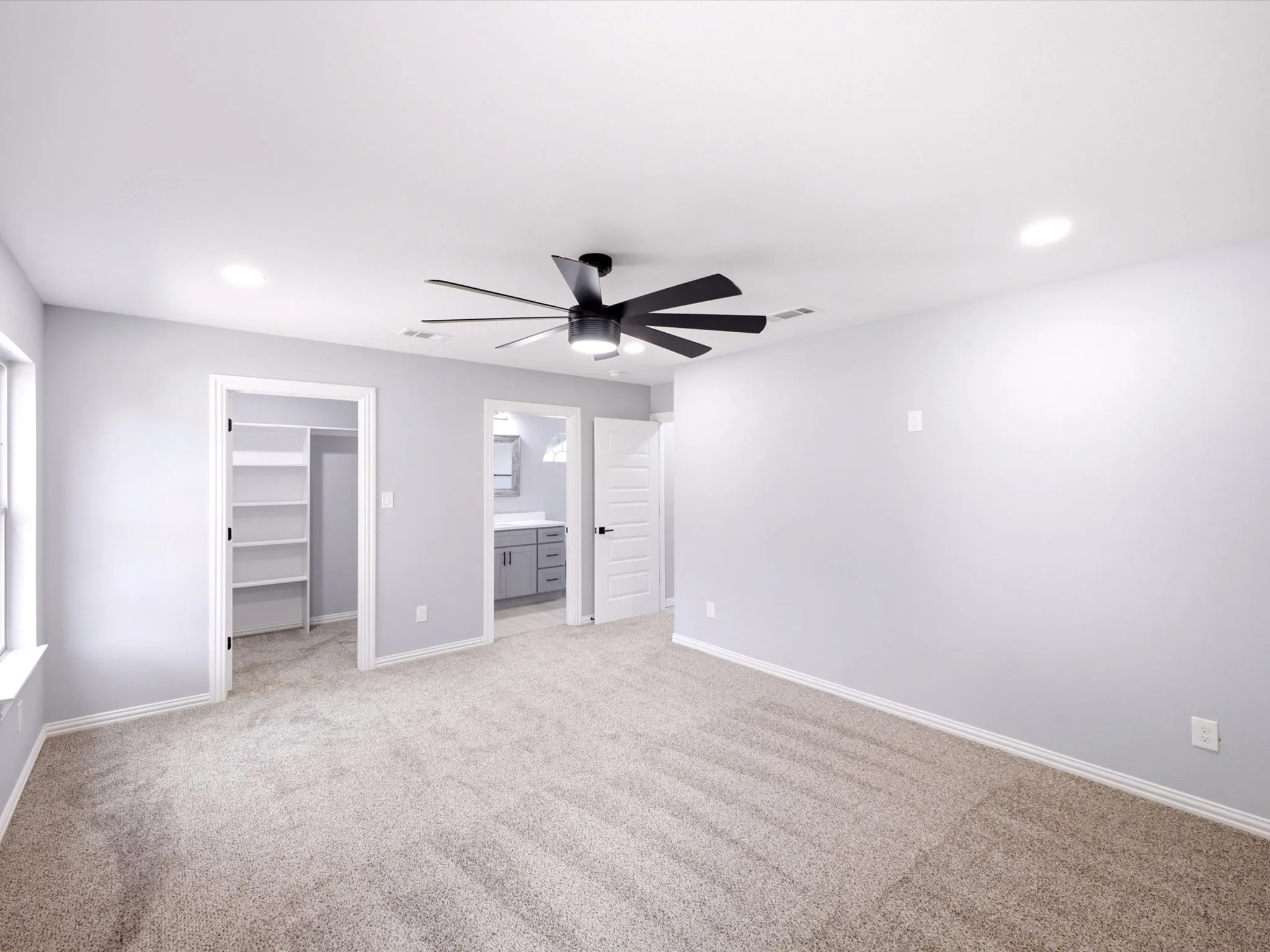 Carpeted flooring, recessed lighting, ceiling fan with integrated lighting, built-in shelving, and vanity with dual sinks