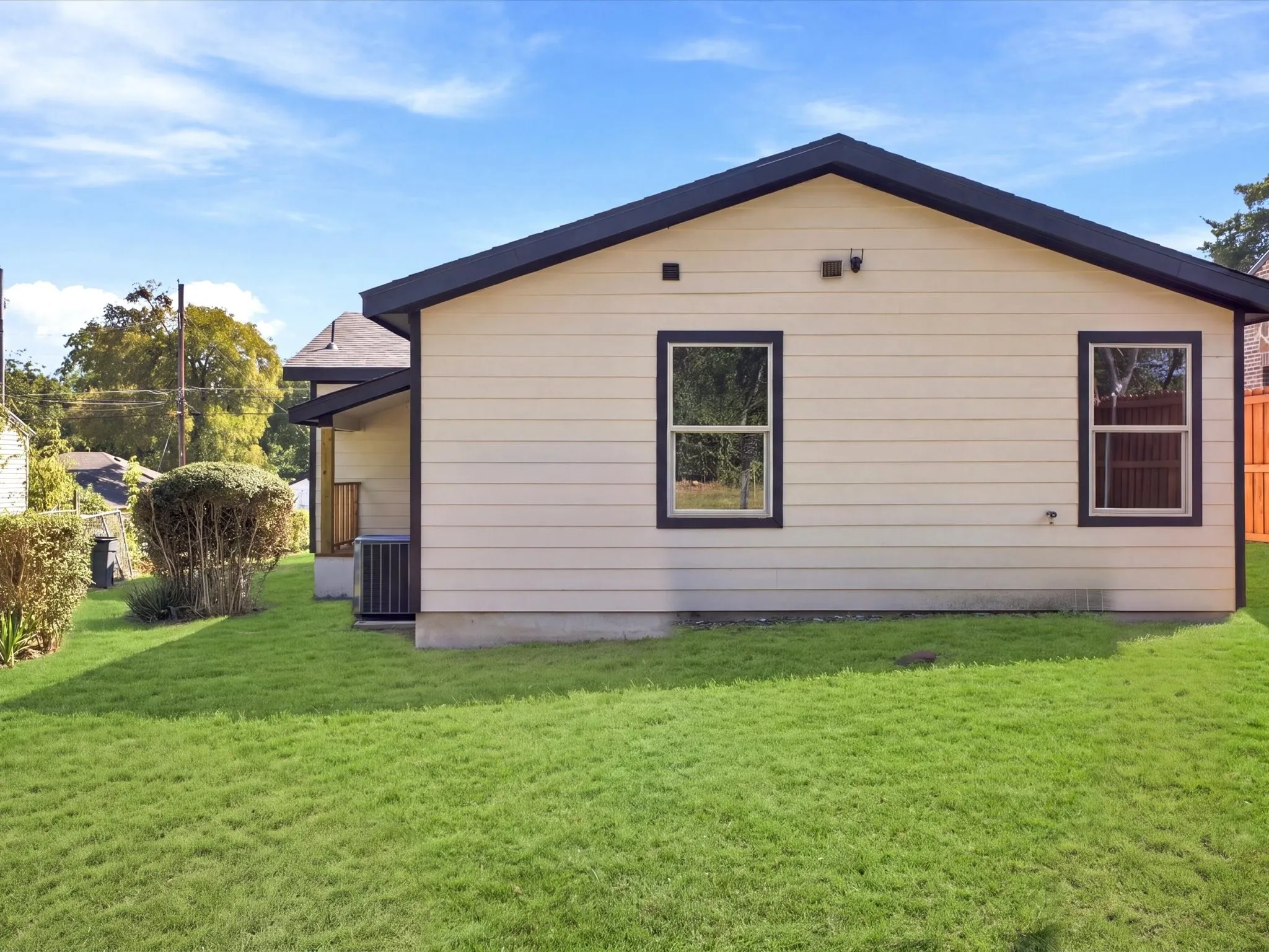Exterior featuring horizontal siding, dark-trimmed windows, a dark shingle roof, and a visible air conditioning unit