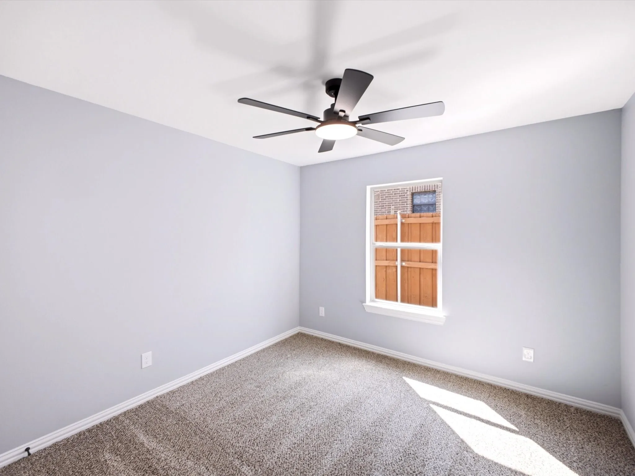 Carpeted room with a single window and a ceiling fan with integrated lighting