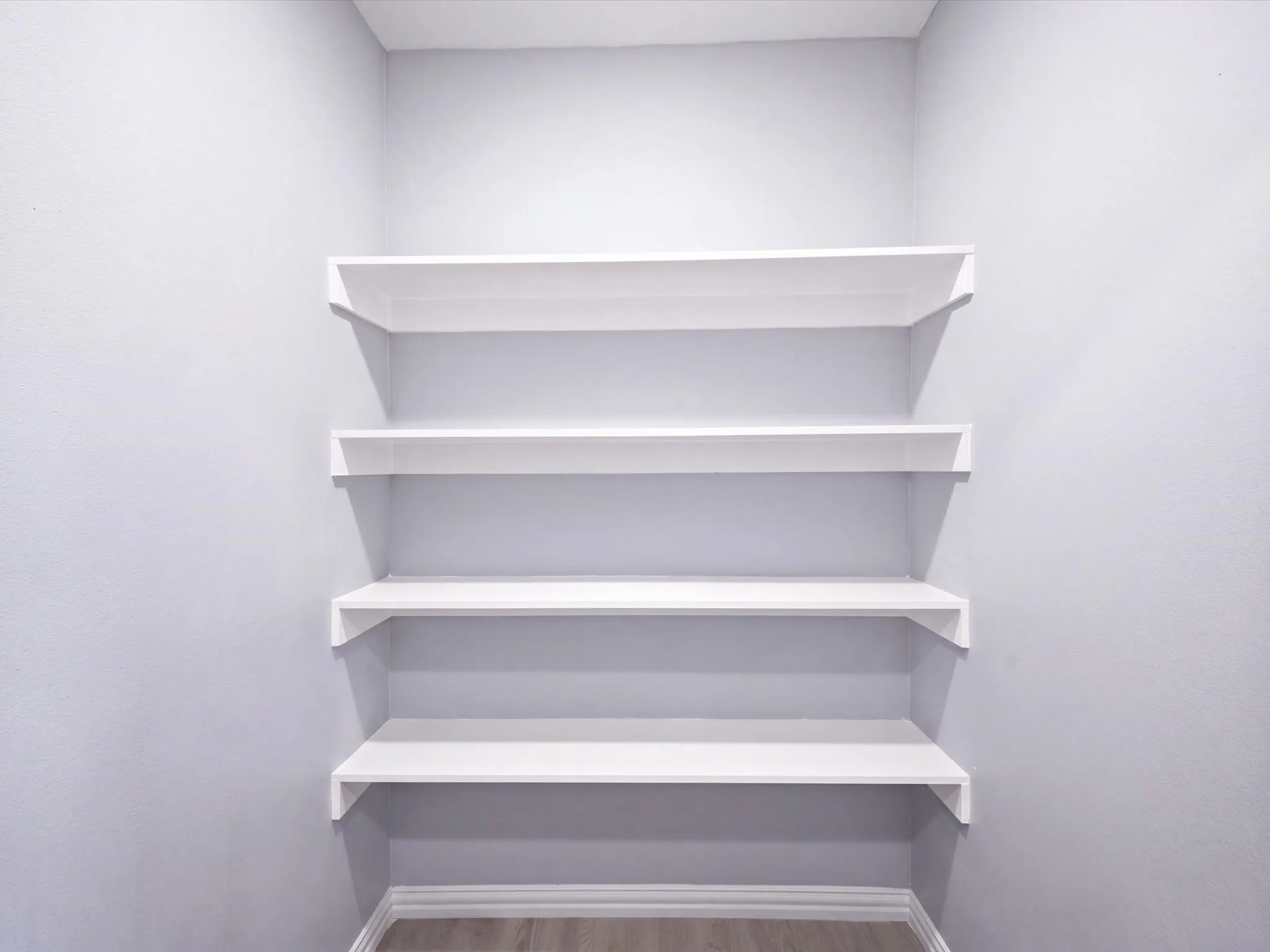 Built-in white shelving, wood-finish flooring