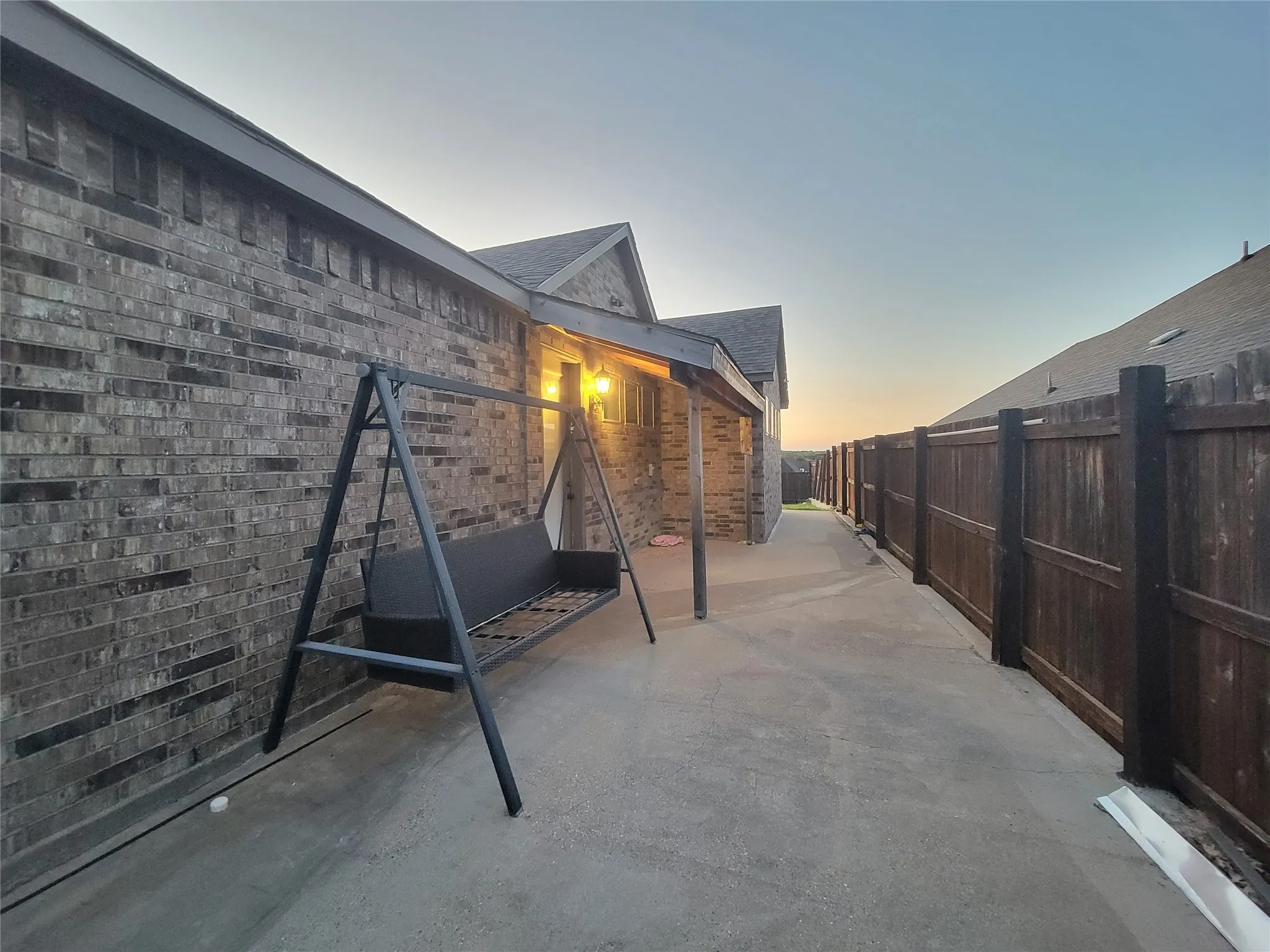 Brick exterior with a covered patio area and concrete walkway
