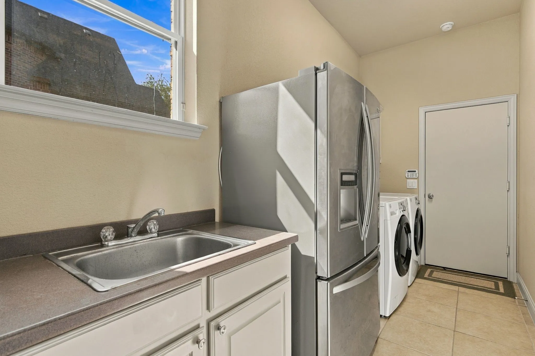 Utility room with sink, has plenty of space for freezer or extra fridge.