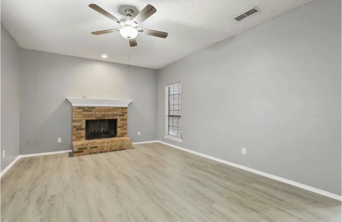 Vaulted ceiling, brick fireplace with mantel, wood-finish flooring, recessed lighting, and ceiling fan