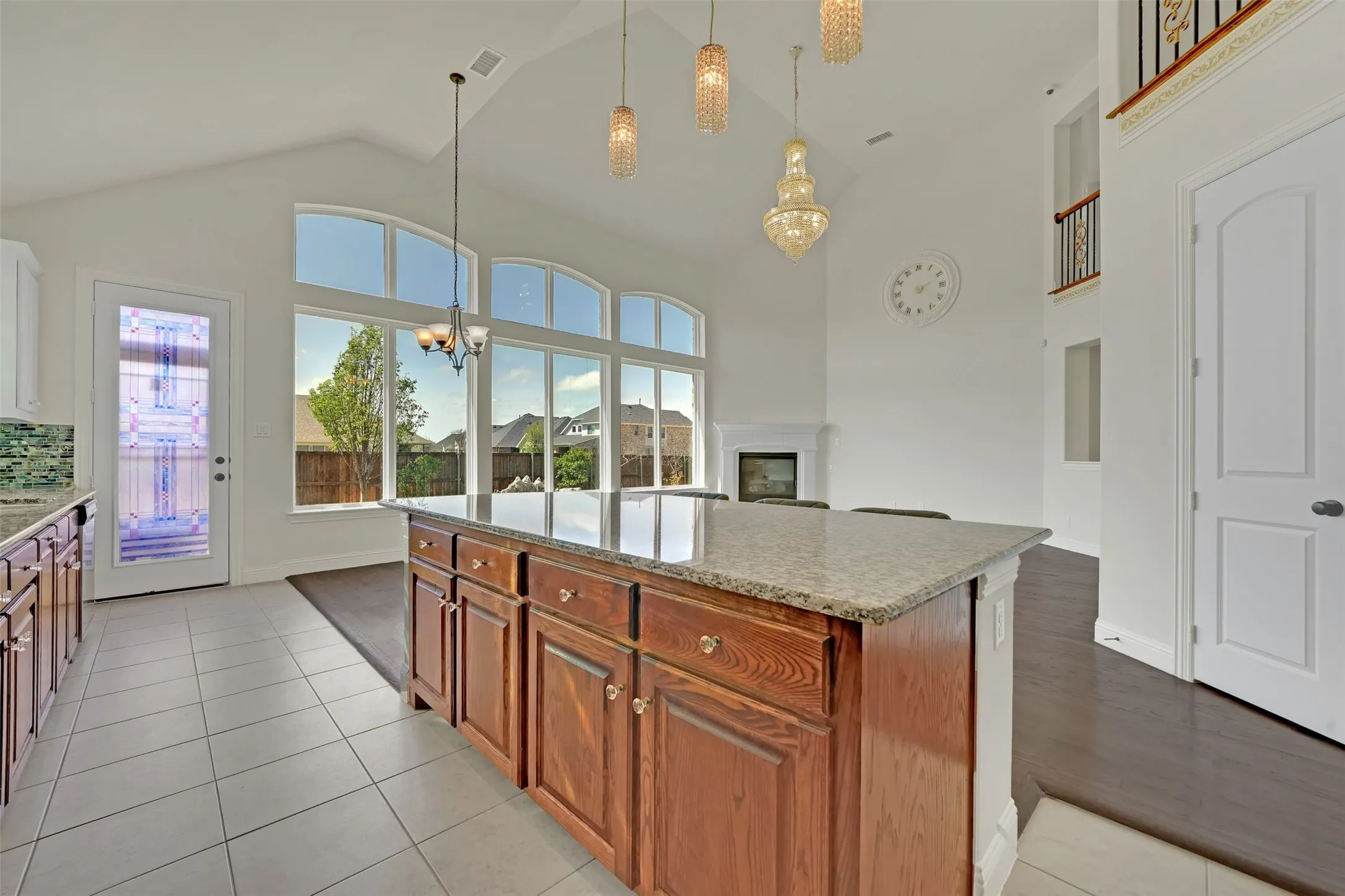 Kitchen island with a light-toned countertop, wood cabinetry, and a tile floor