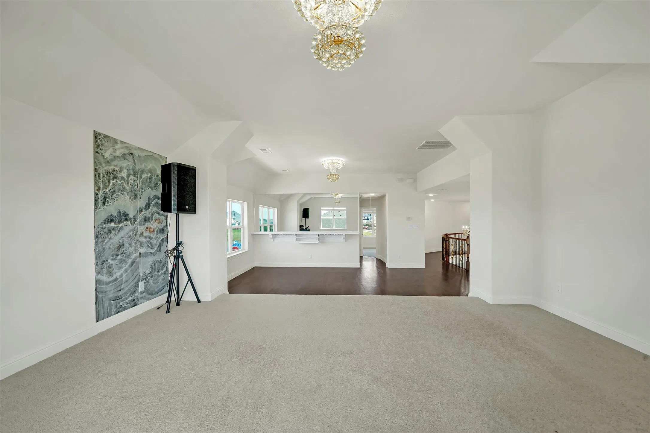 Recessed ceiling detail with an ornate chandelier, neutral carpeting, and a built-in bar with a countertop