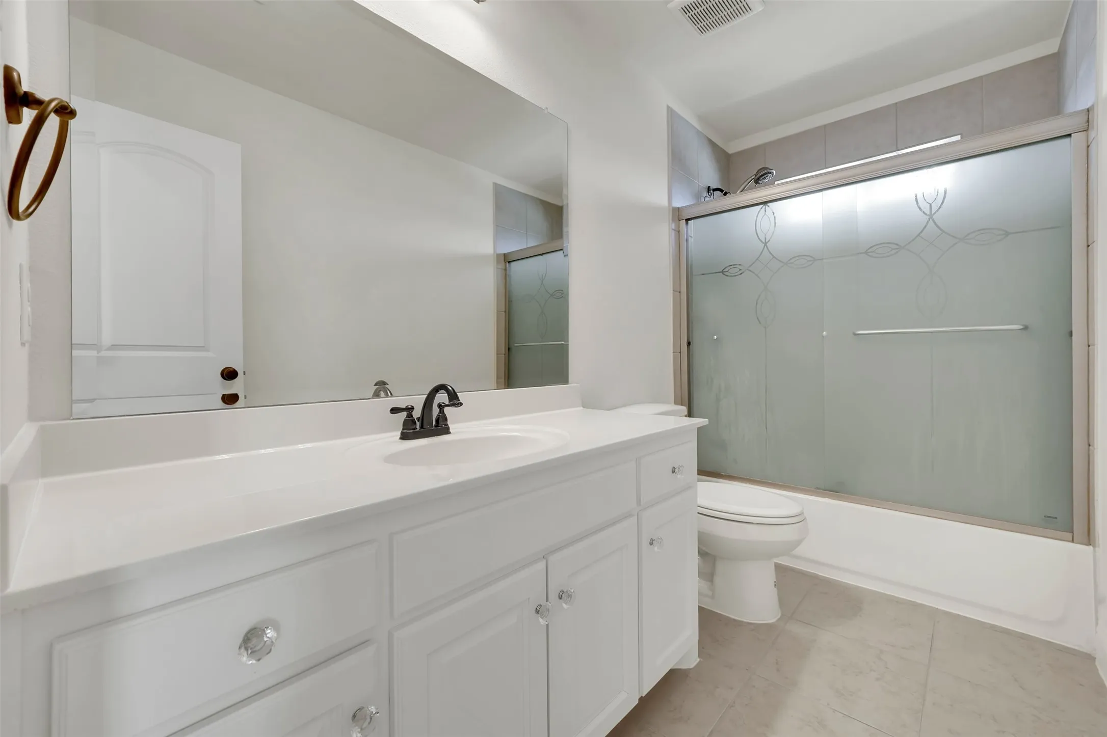 White vanity with clear knob hardware, integrated sink, and dark bronze faucet