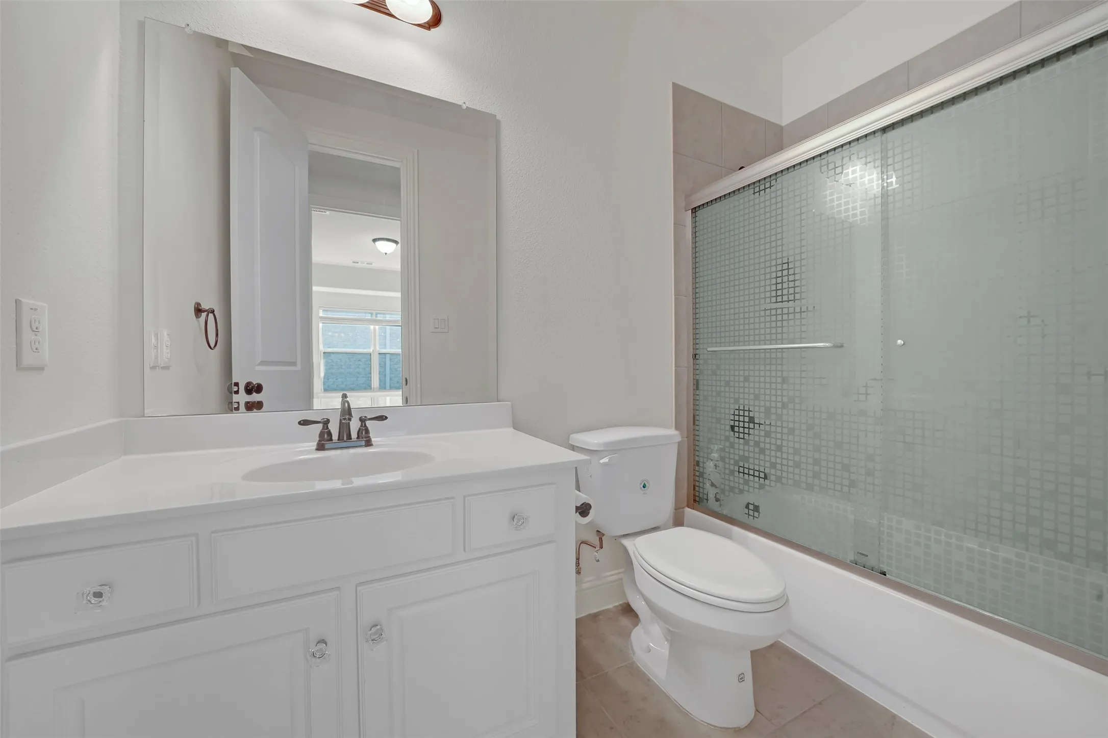 White vanity with integrated sink, bronze-finish faucet, and crystal-style drawer pulls