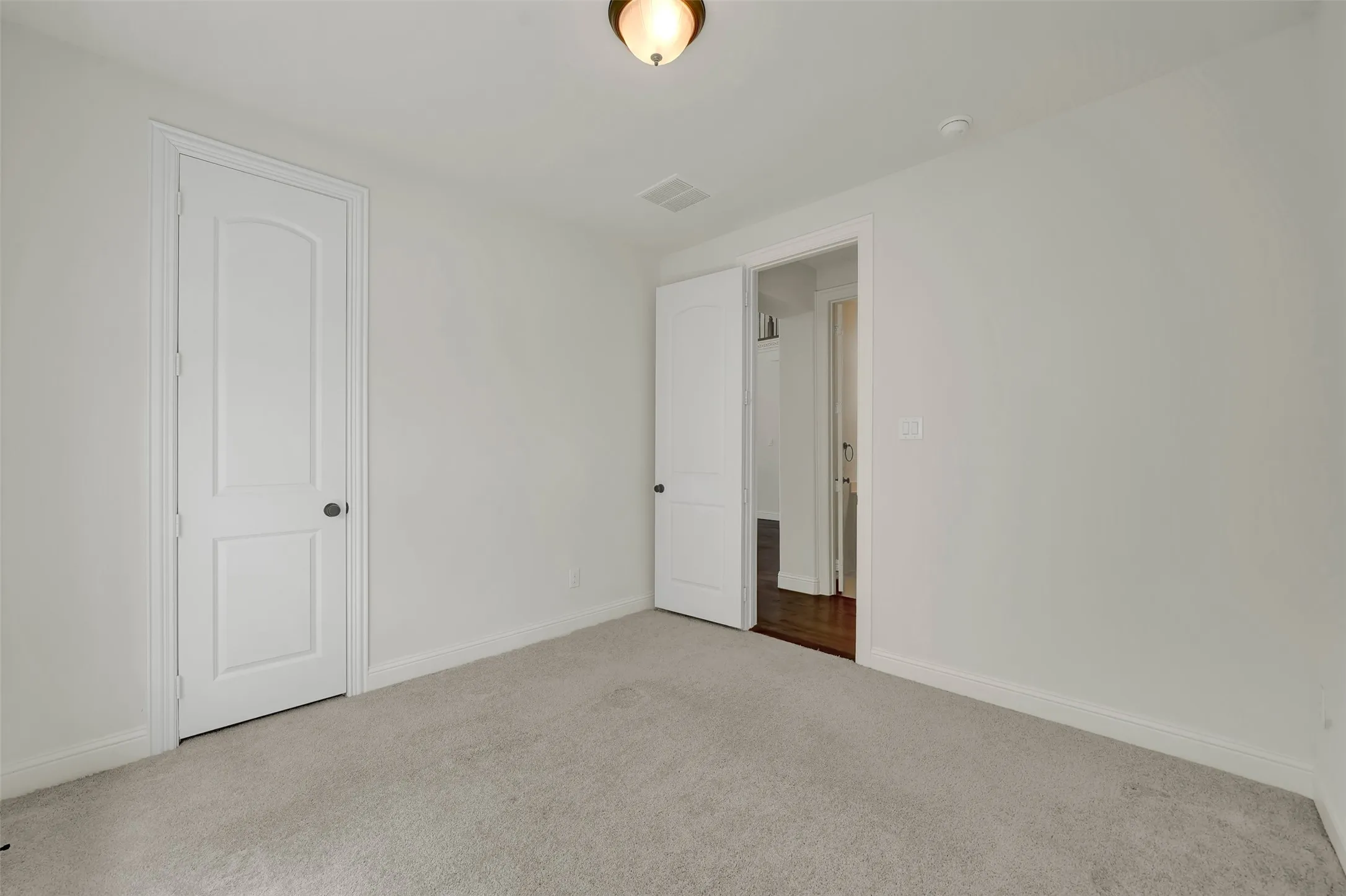 Neutral wall tones, light-colored carpeting, white trim, and white paneled doors