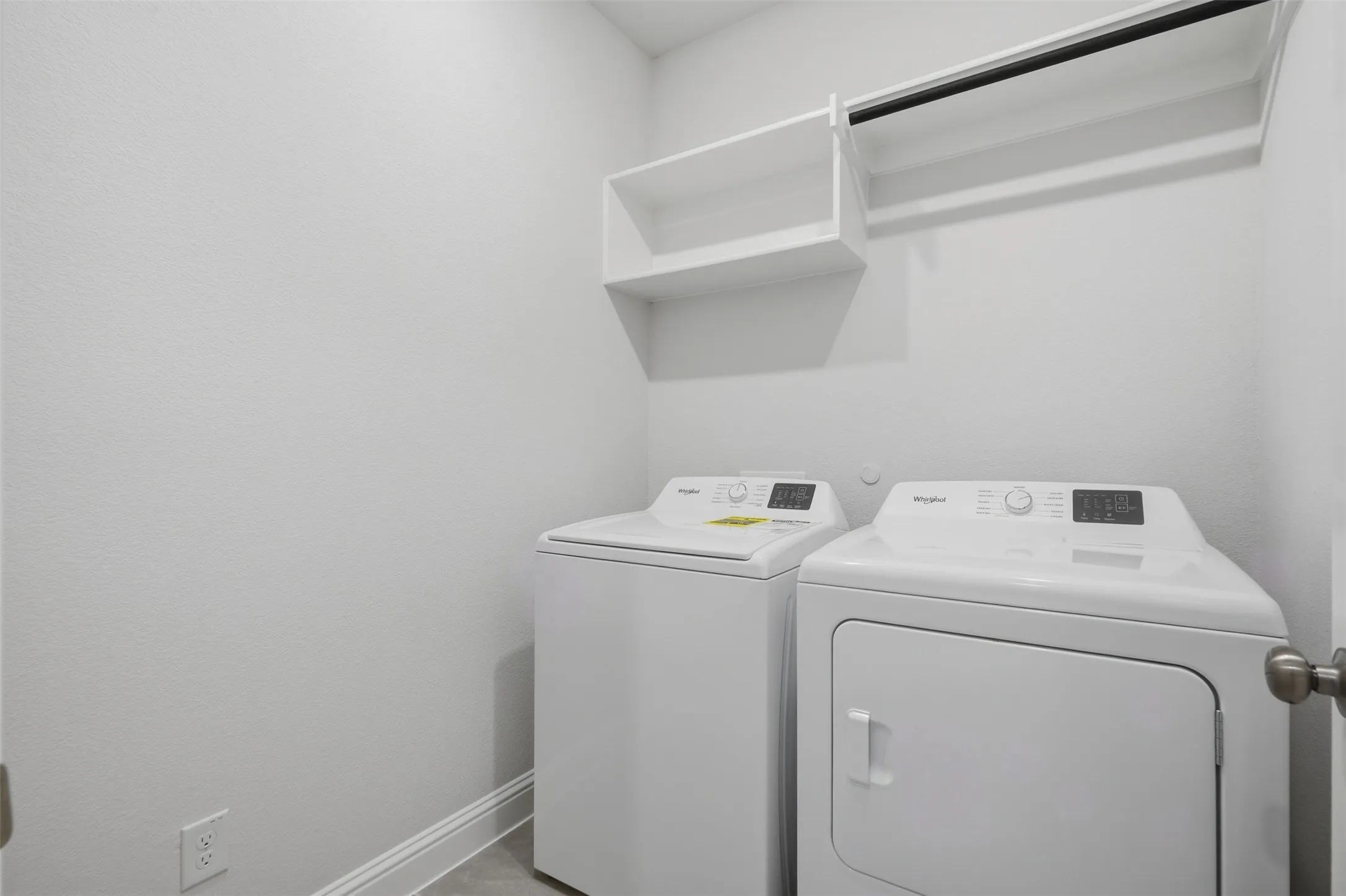 White built-in shelving, integrated hanging rod, and light-toned flooring