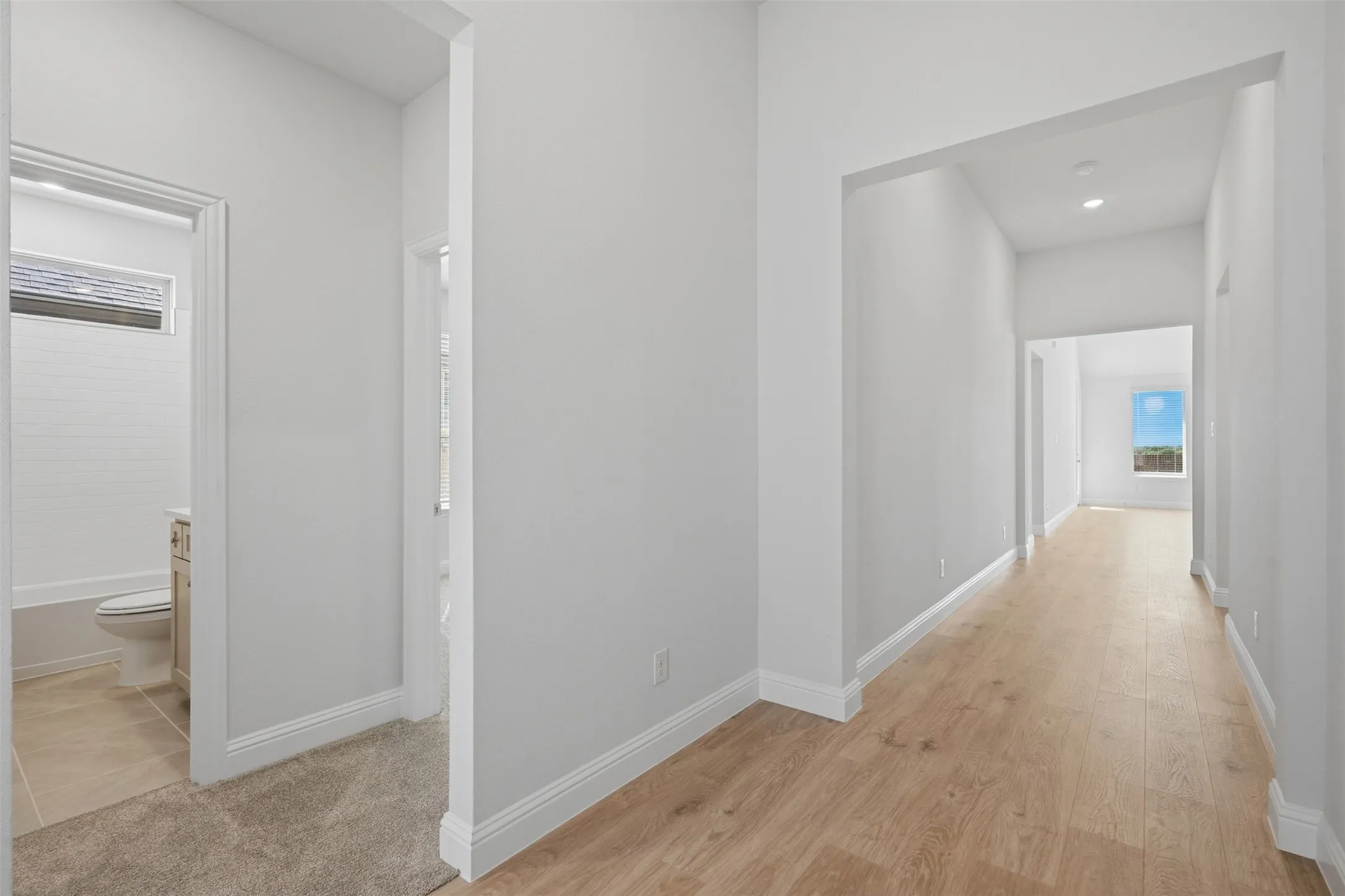 Hallway with wood-finish flooring and recessed lighting