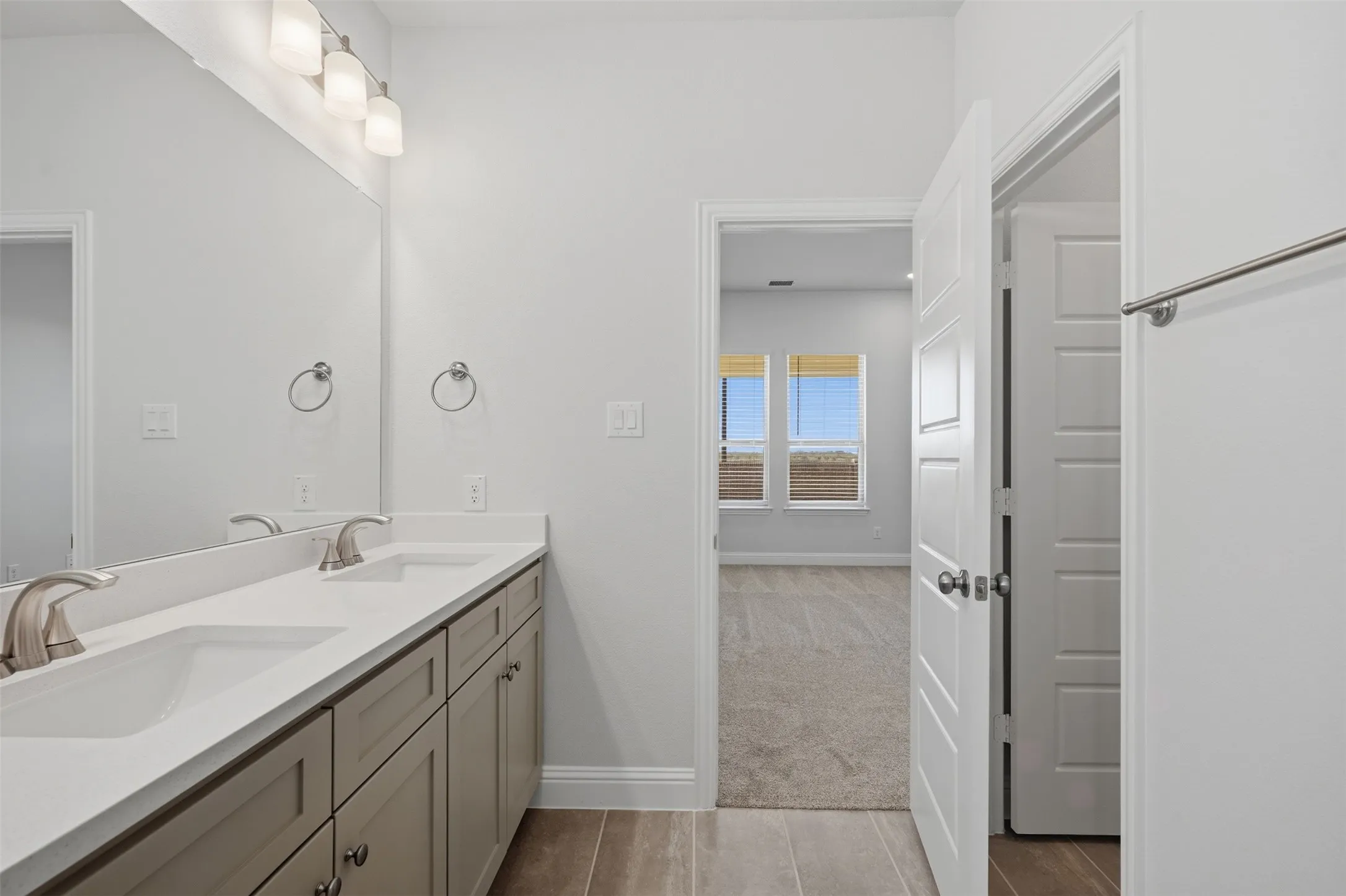 Dual vanity with integrated sinks, brushed nickel faucets, and under-sink cabinetry