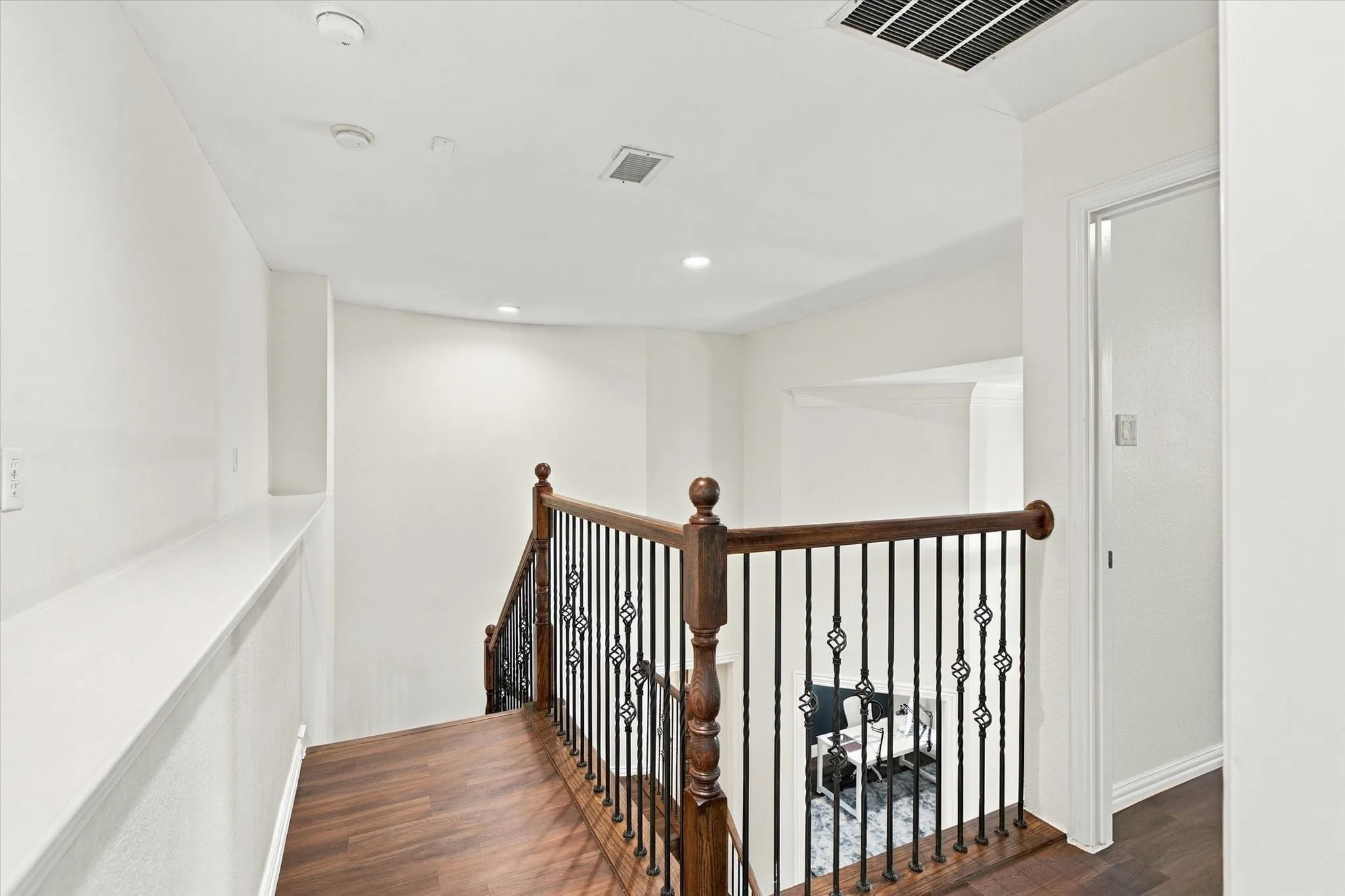 Wood-finish flooring with a decorative iron and wood banister