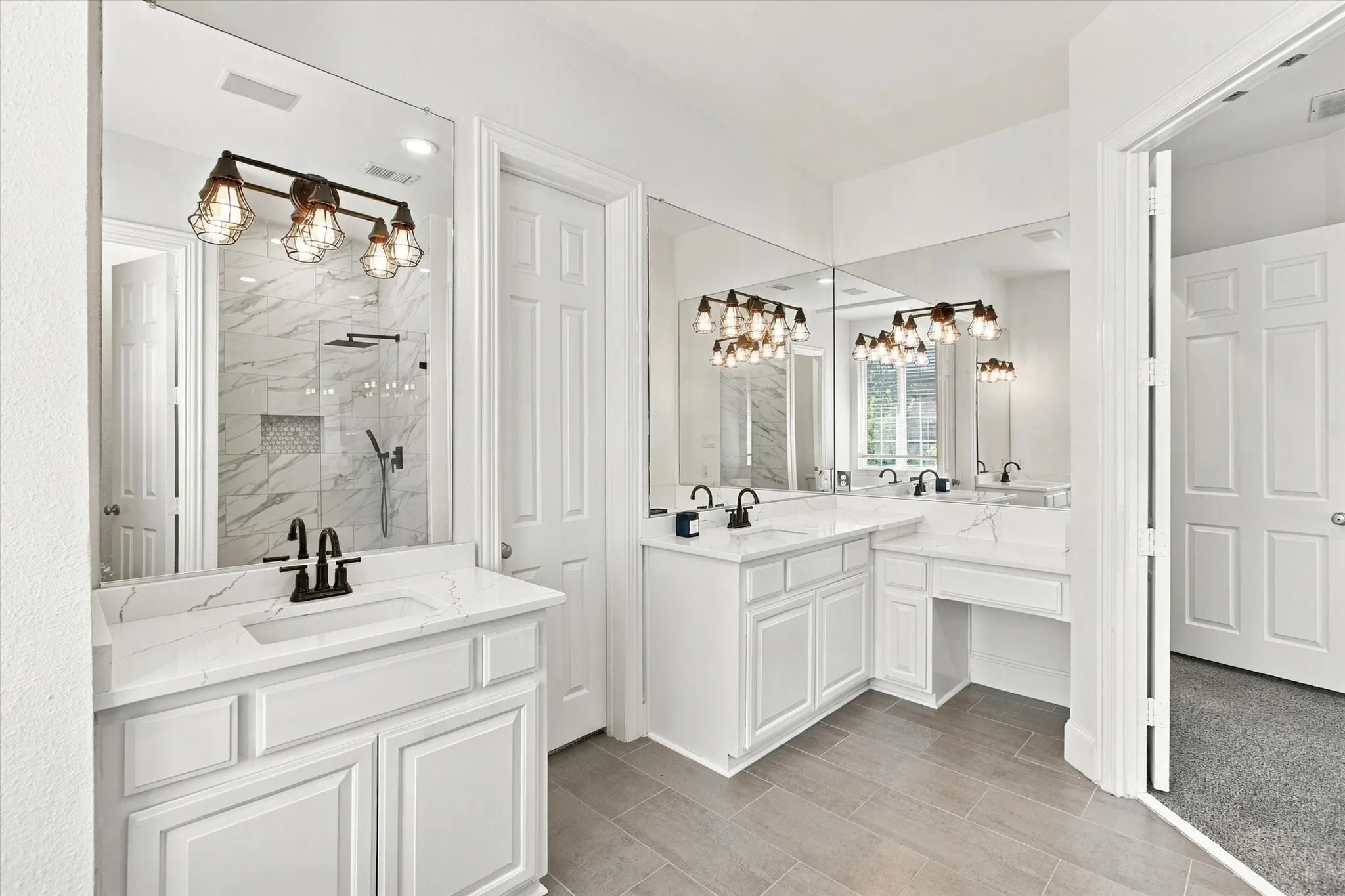 Dual white vanities with integrated sinks and white countertops, large wall-mounted mirrors, plank-style tile flooring, and a walk-in shower with tile surround