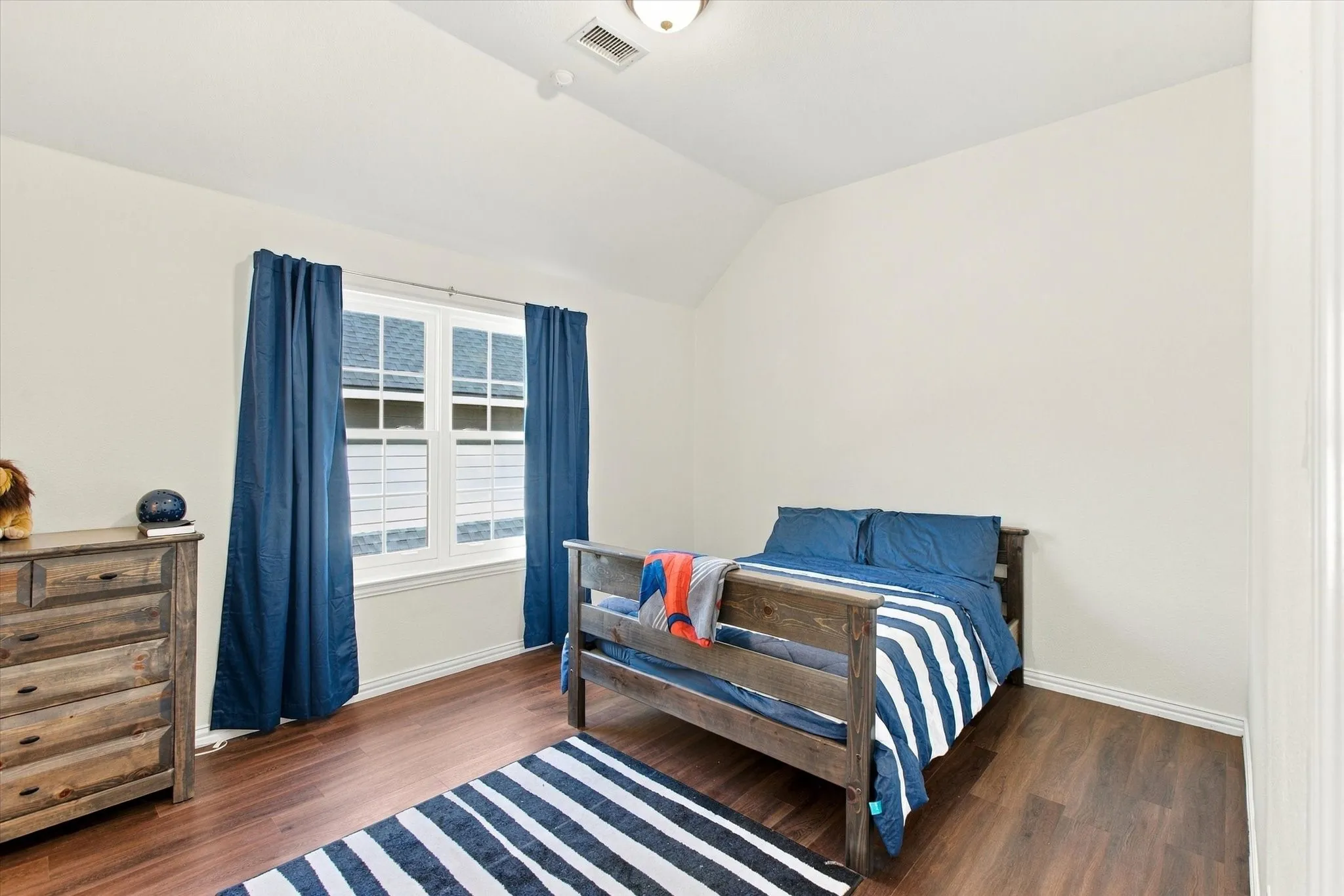 Vaulted ceiling, recessed lighting, wood-finish flooring, and a double-hung window