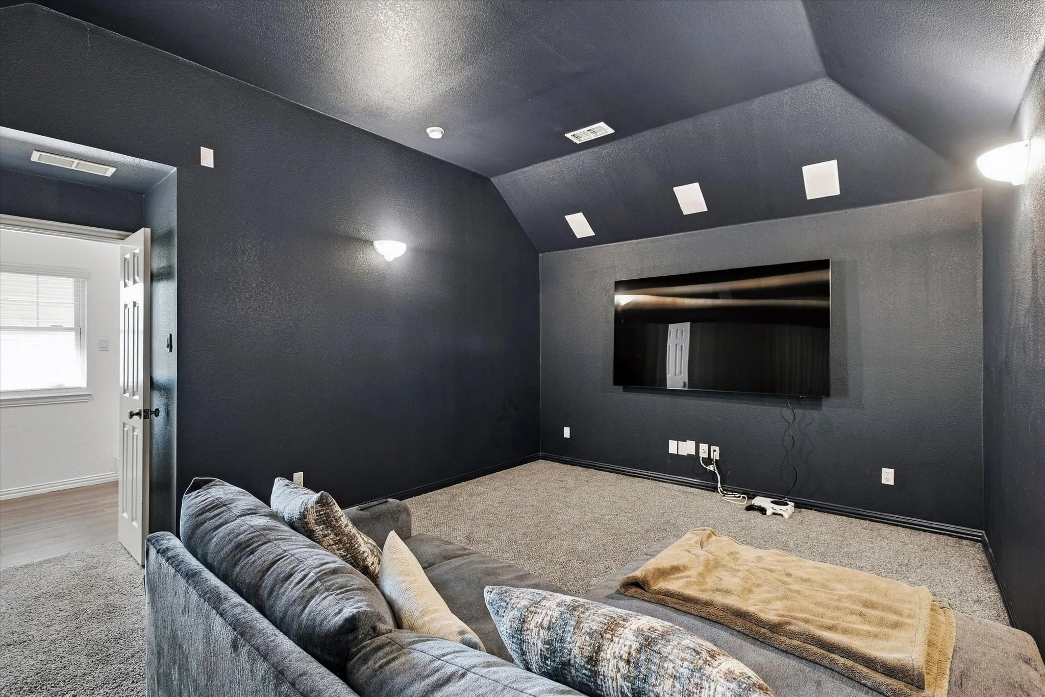 Carpeted flooring, vaulted ceiling, recessed lighting, and wall-mounted sconces