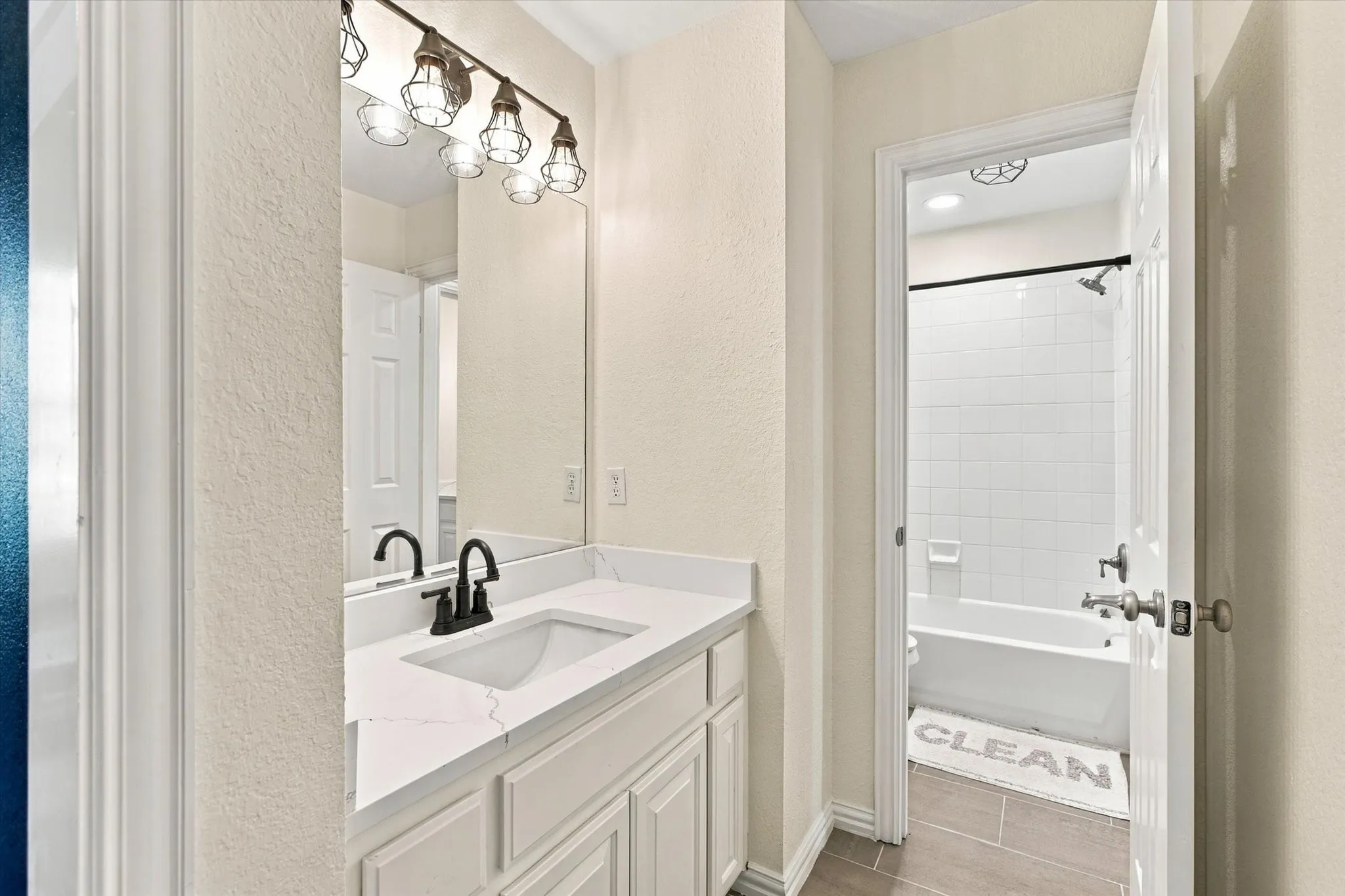 Vanity with white cabinetry, a white countertop, and a black faucet