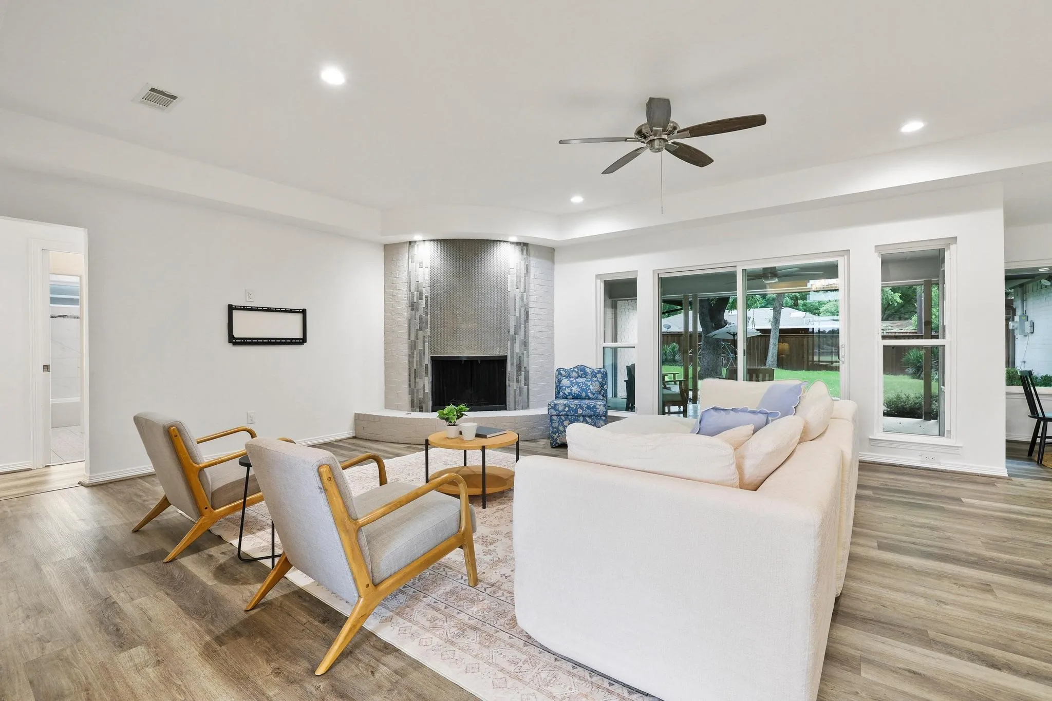 Wood-finish flooring, recessed lighting, and a ceiling fan with integrated lighting